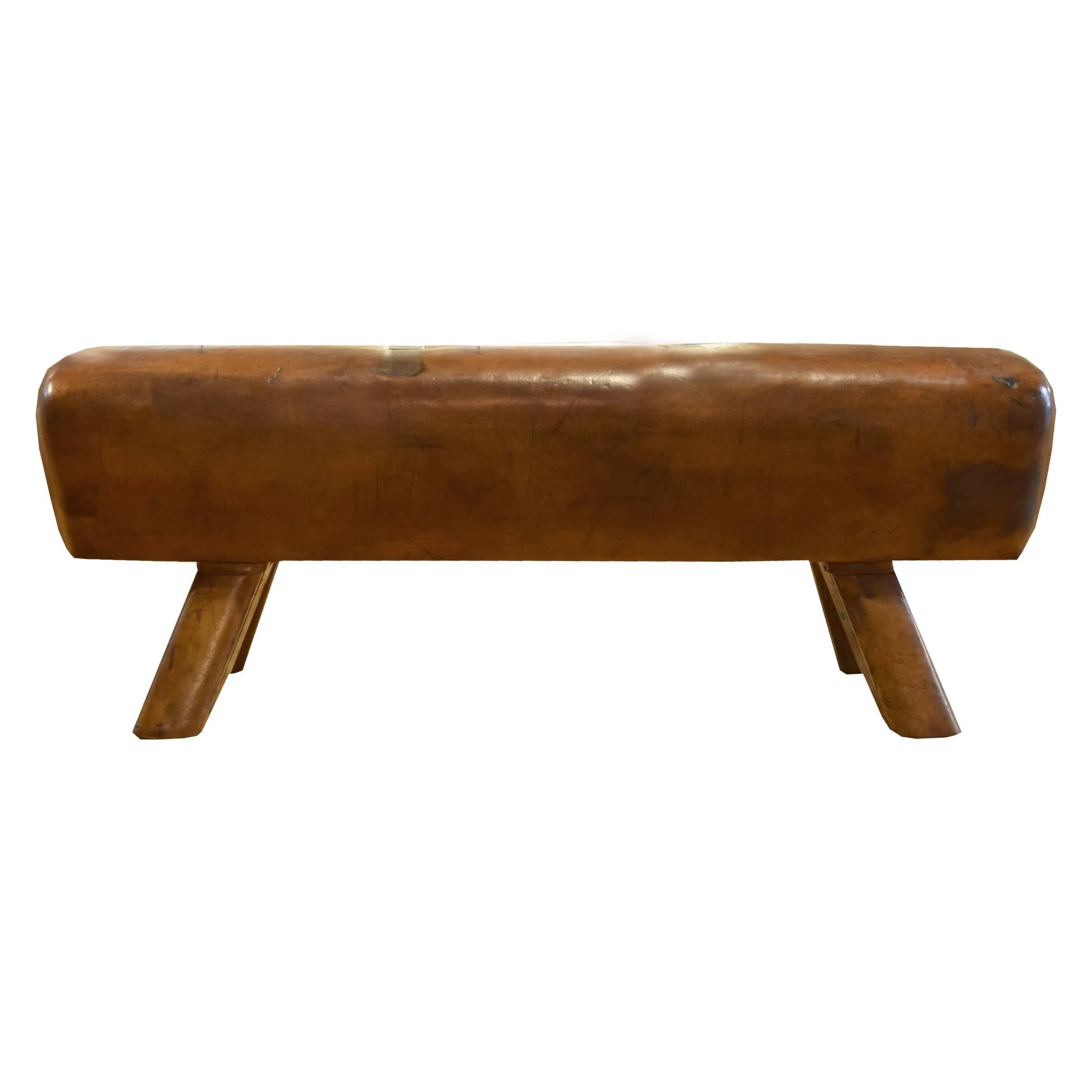 A fantastic early 20th century Czech leather pommel horse bench with leather covered wooden legs and custom steel plates covering the location of the original handles.