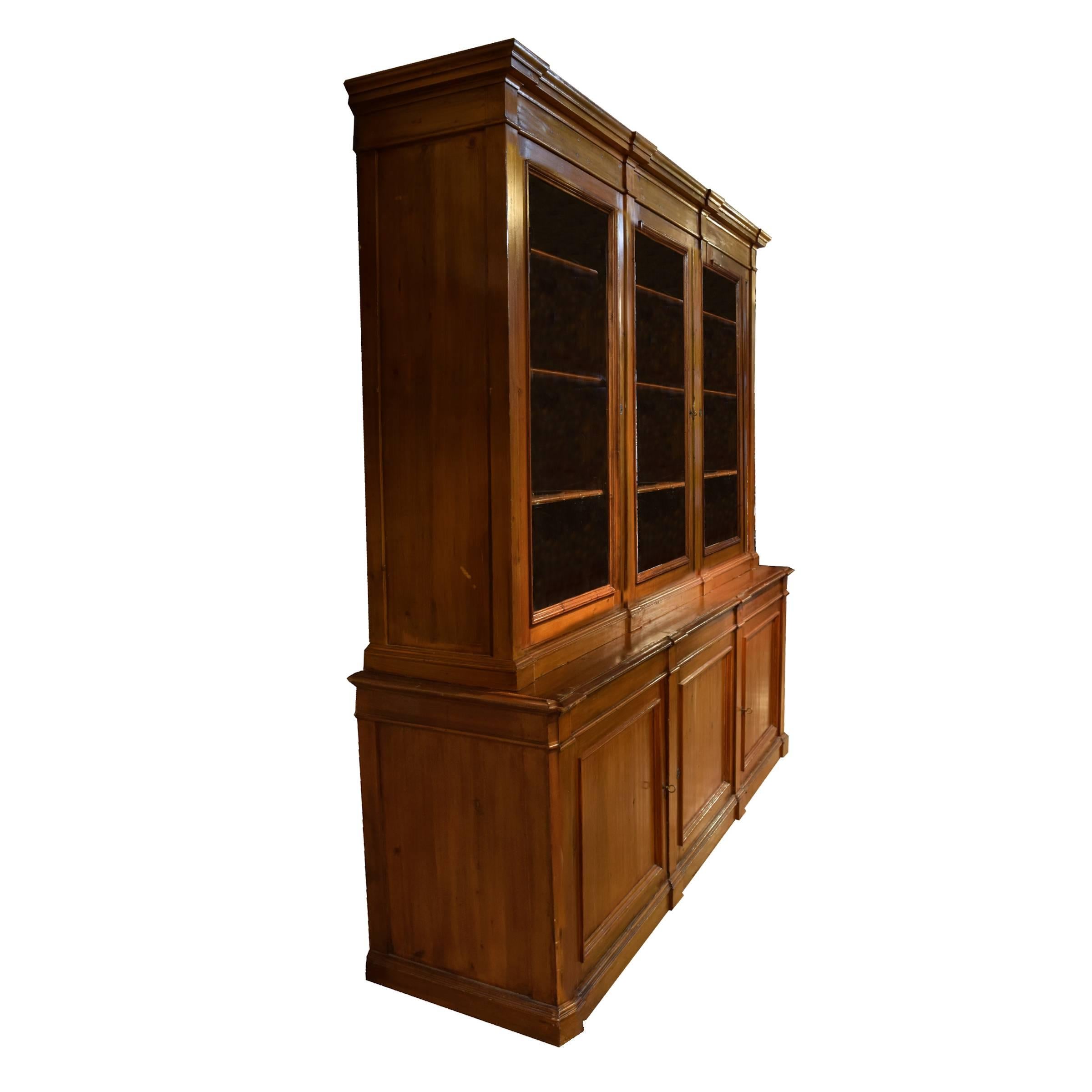 A fabulous Italian pine display cabinet with three doors on the bottom and three doors with glass on the top. Great quality, circa 1920.
 