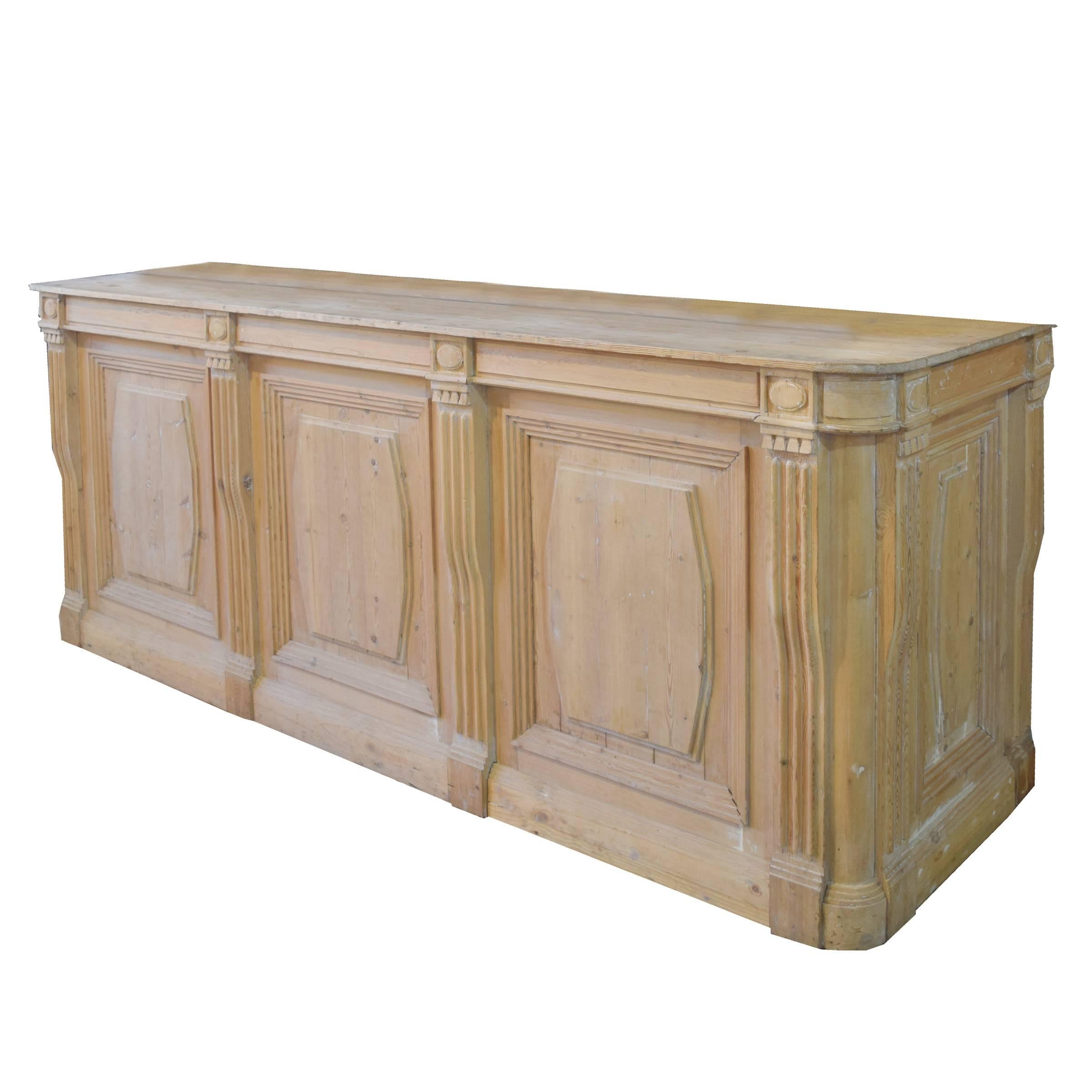 A beautiful 19th century French pine shop counter with paneled sides, fluted pilasters and two drawers in the back.
     
