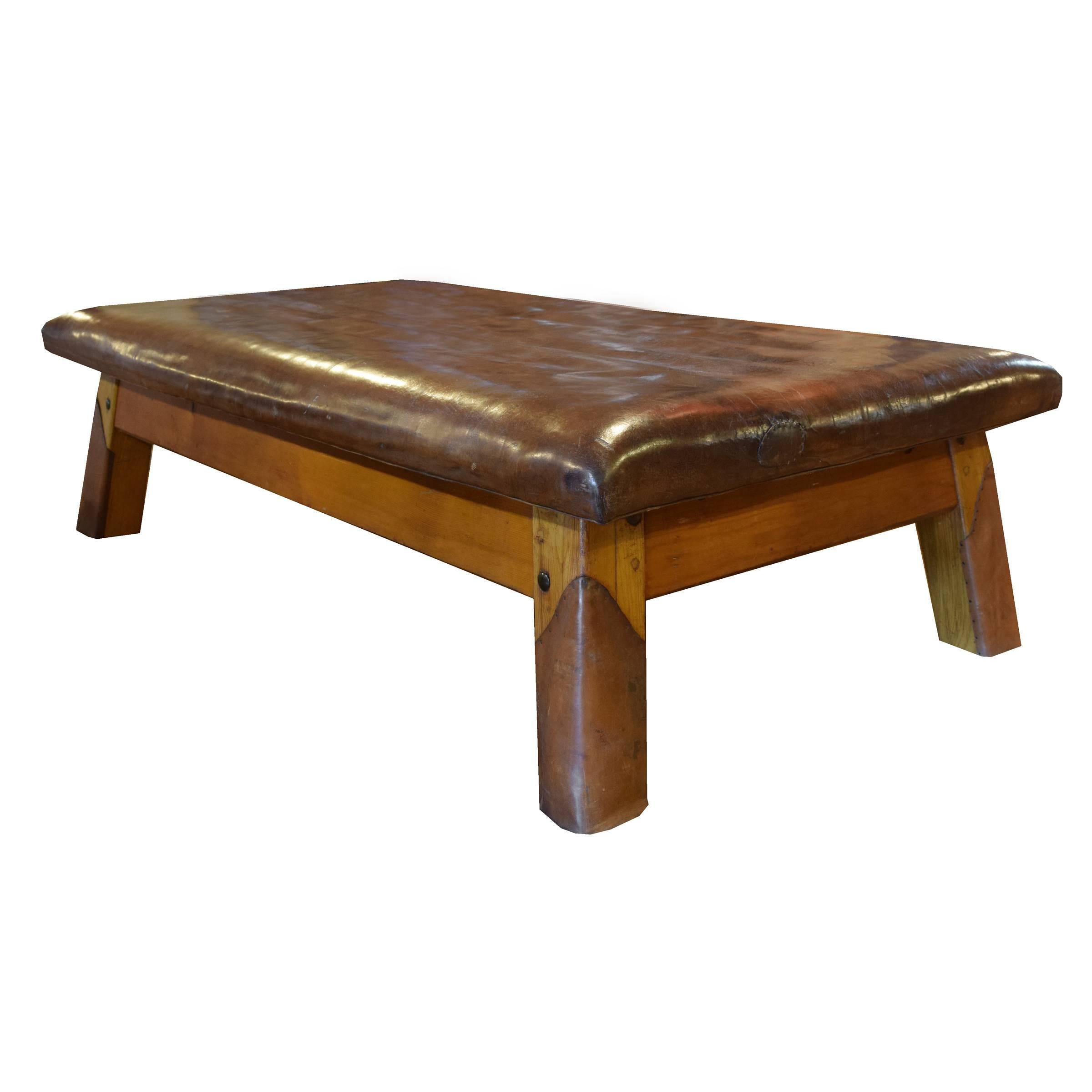 A wood and leather vaulting bench with wonderfully worn leather top and slightly tapered leather wrapped square legs from a gymnasium in the Czech Republic, circa 1930.
  