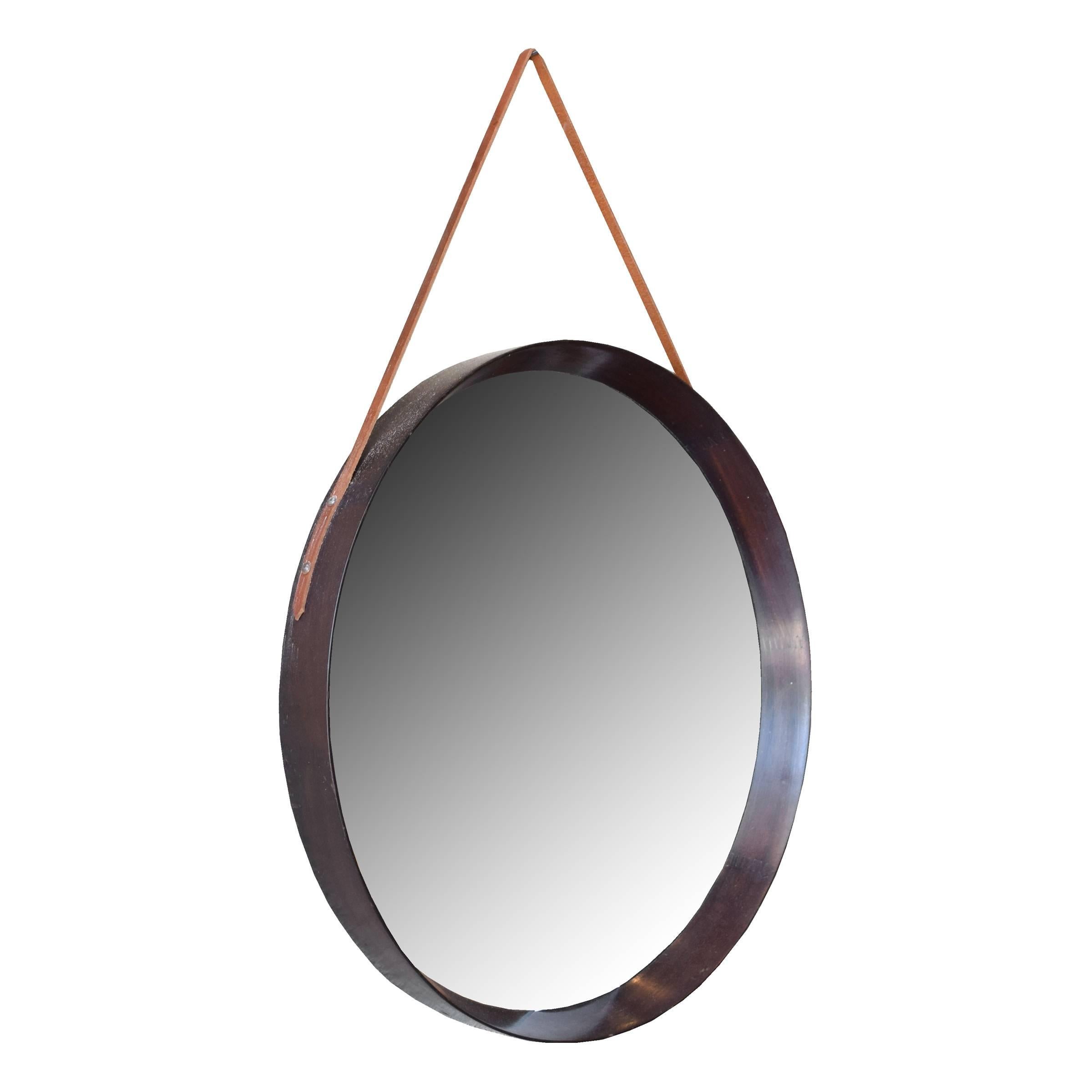An Italian Mid-Century round mirror with a mahogany frame and newer leather strap.