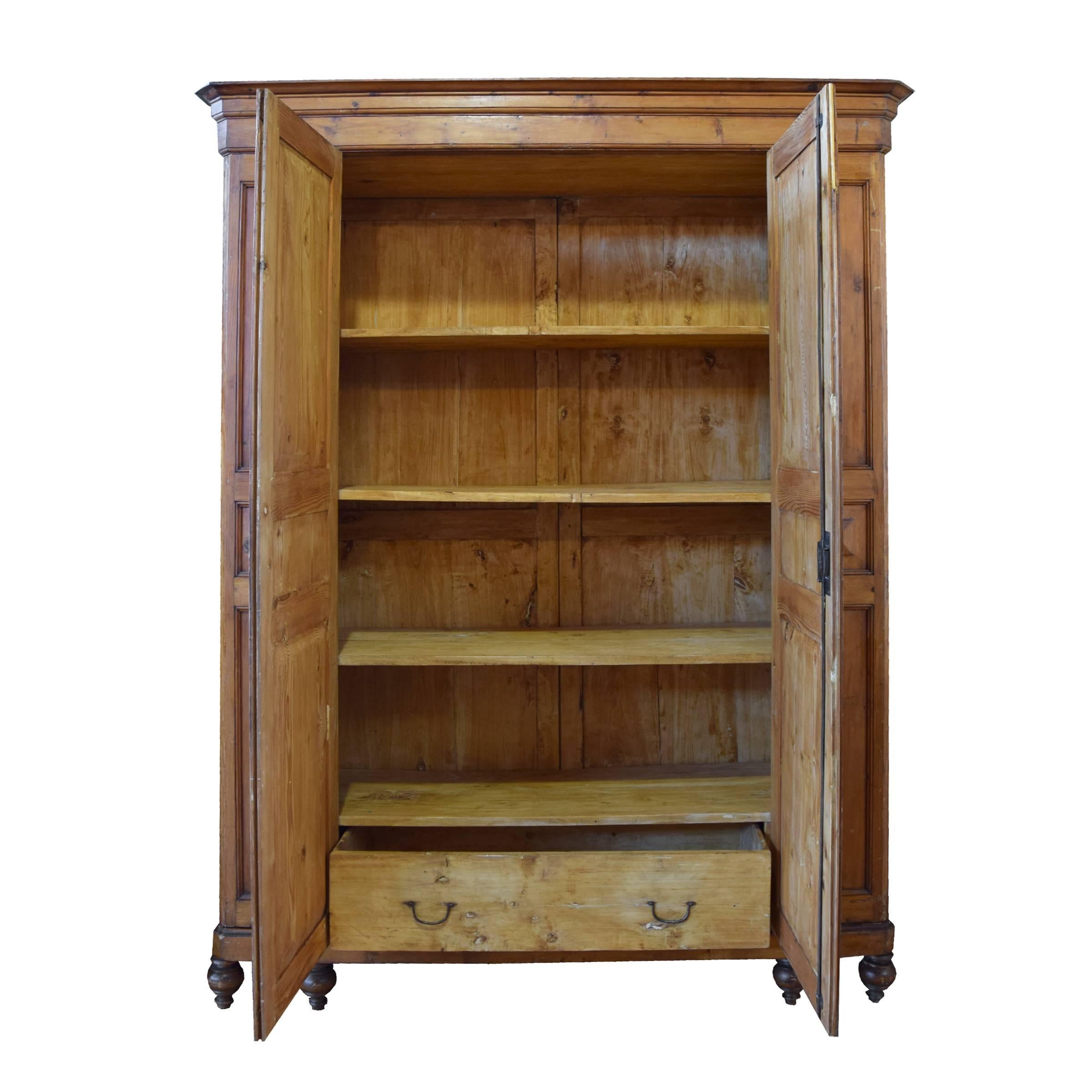 A lovely Northern European pine armoire with two doors, large interior drawer, and four shelves, on four raised feet, circa 19th century.
 