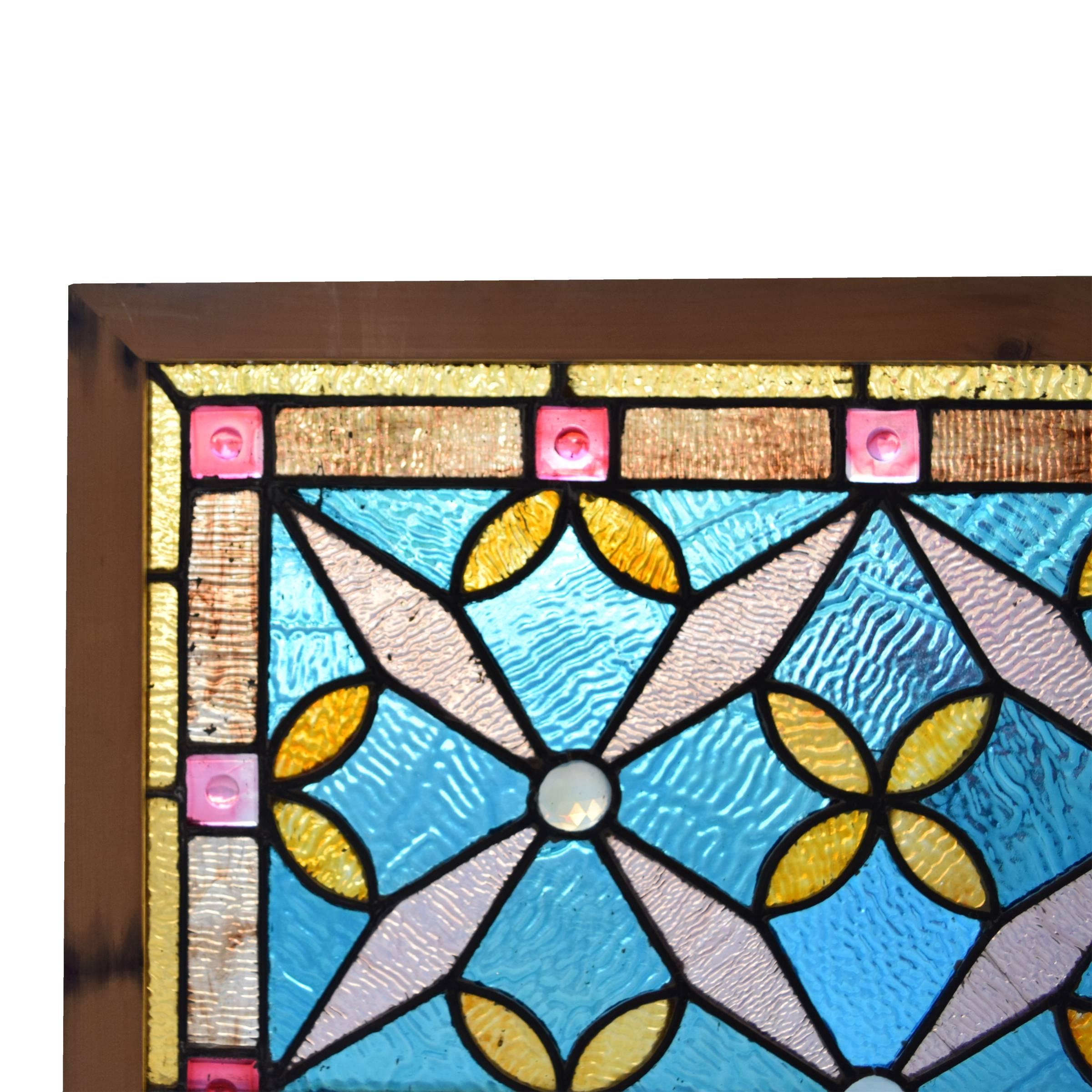 A gorgeous American stained glass and jeweled window in blues, pinks and yellows, circa 1890.
 