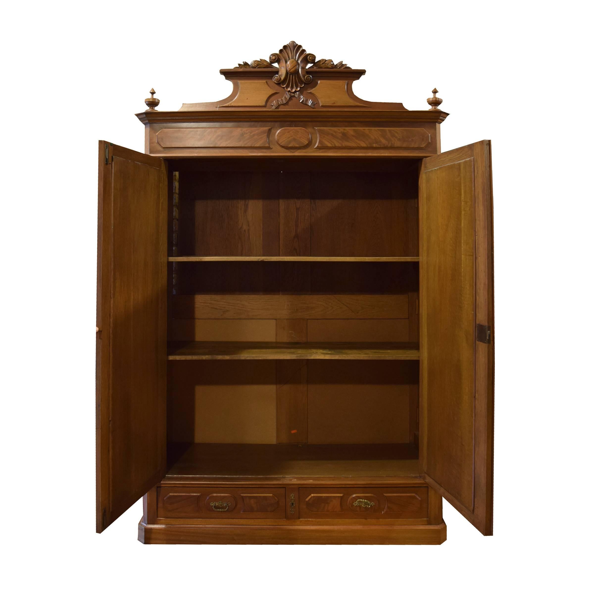 An American two-door mirrored armoire with three shelves and two drawers.