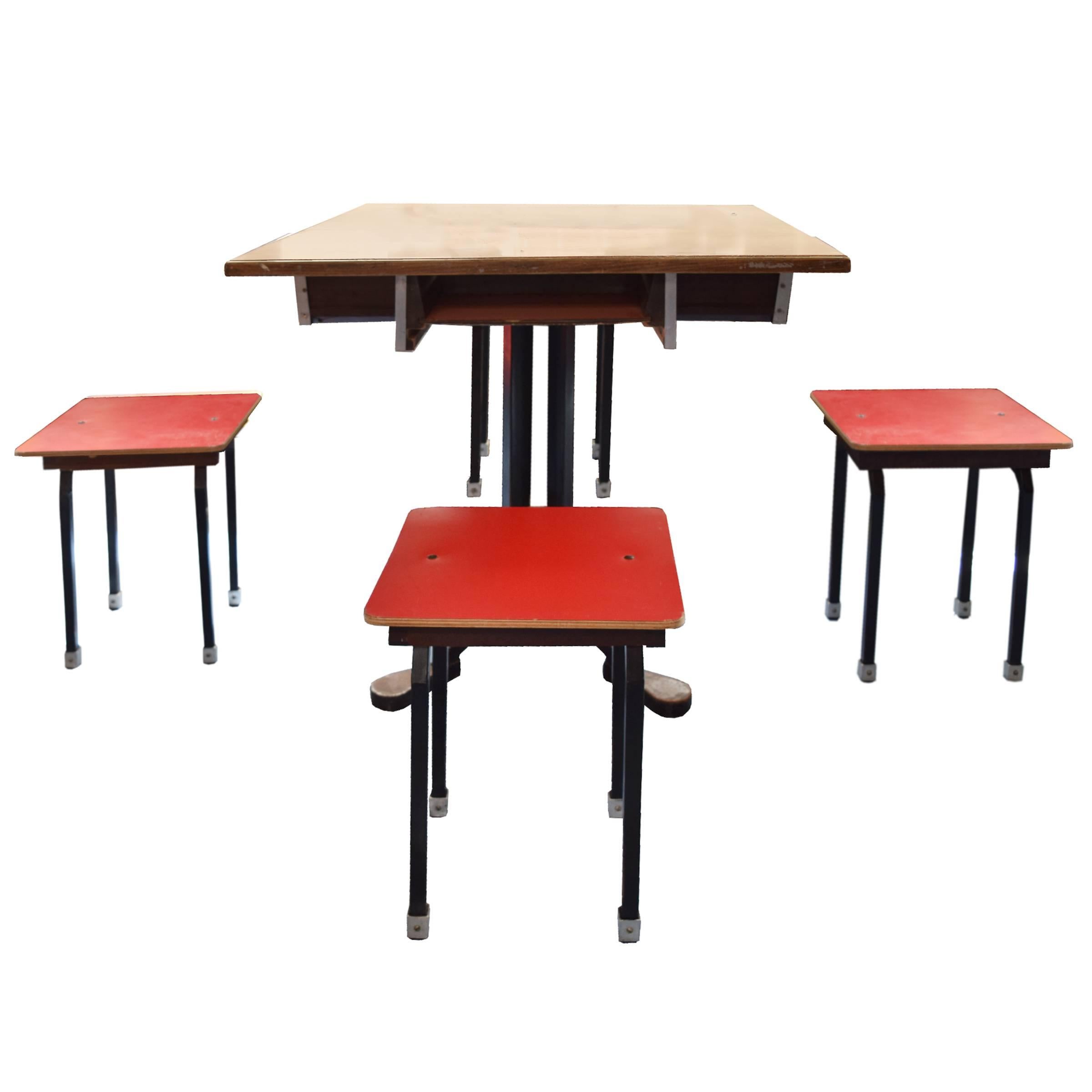 A great German cafe table with four stools that neatly slide in the tabletop for storage, circa 1960.