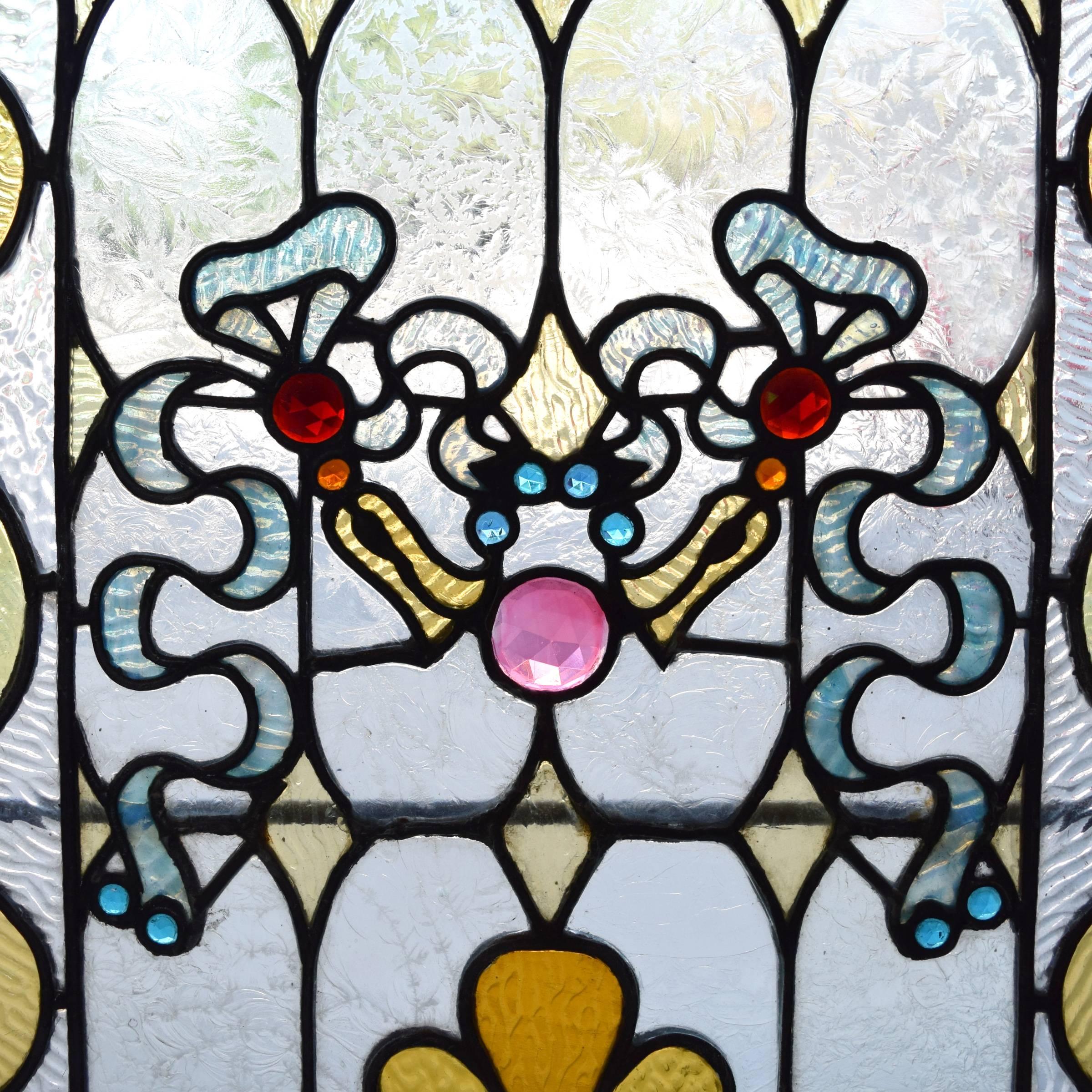 An American stained glass window with glue chip glass and colorful jewels, circa 1890.