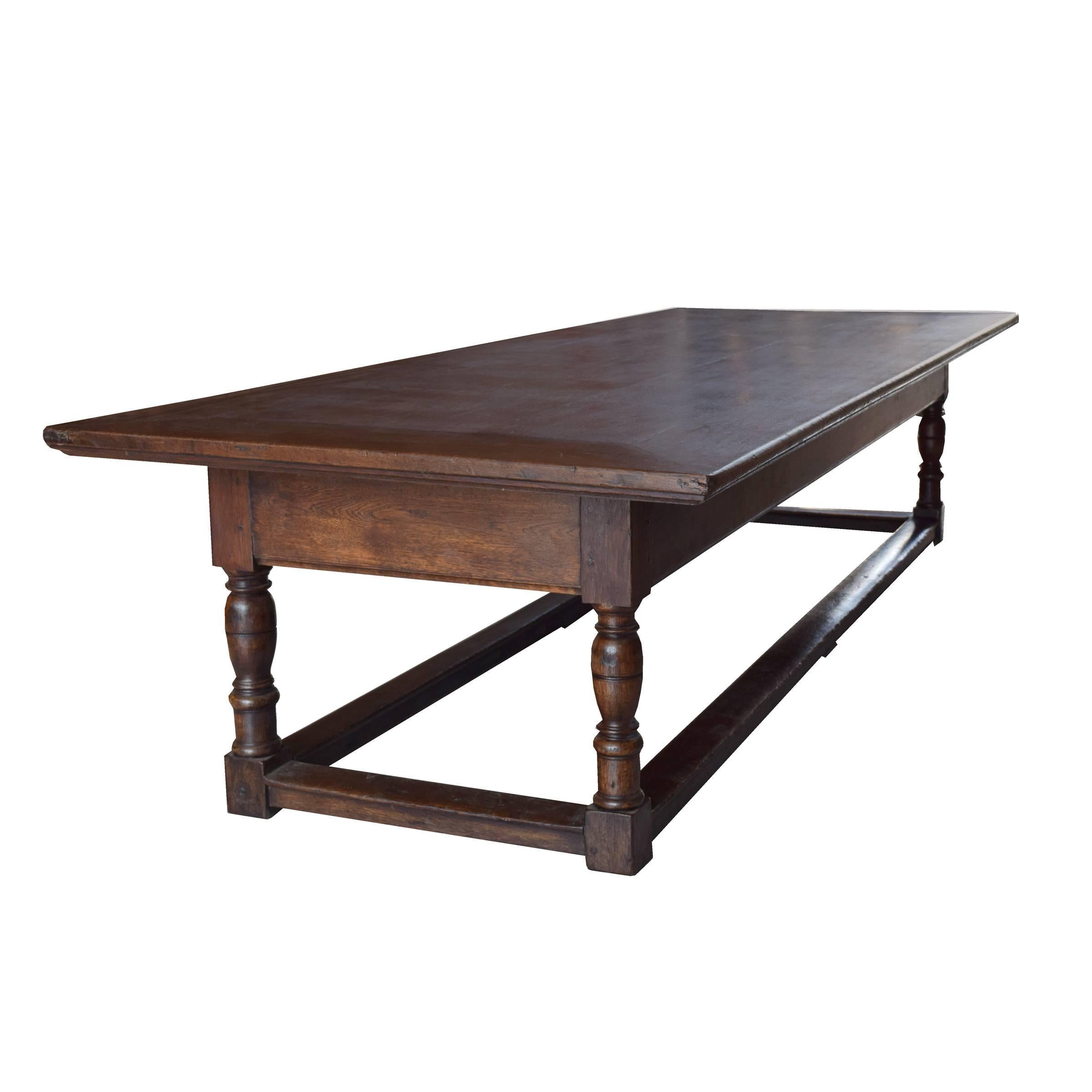 A monumental French refectory oak table of excellent quality with four turned legs and stretchers on all sides, late 18th-early 19th century.