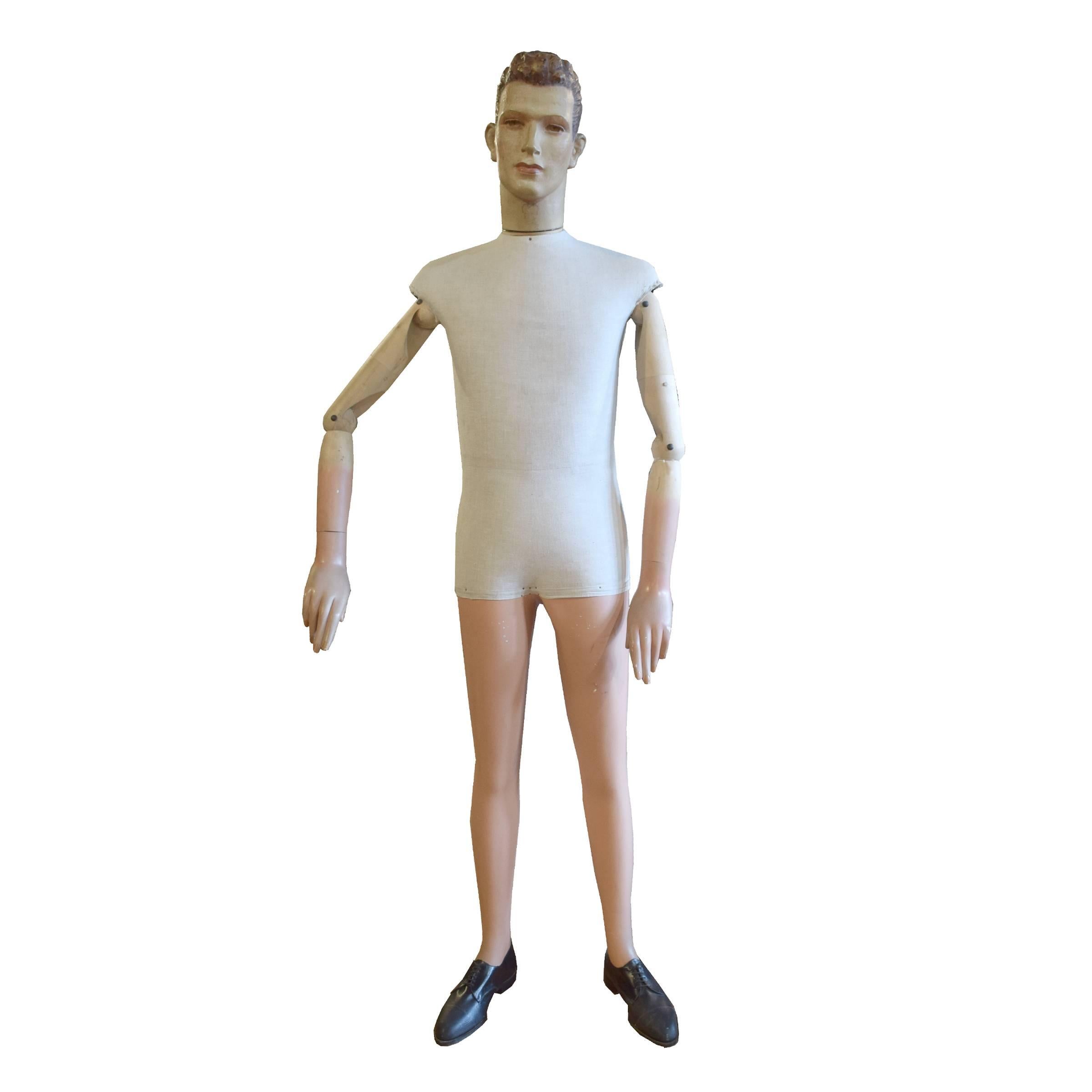 A French articulated mannequin with fully adjustable wood arms, a cloth body, and plaster legs and head, and period shoes.