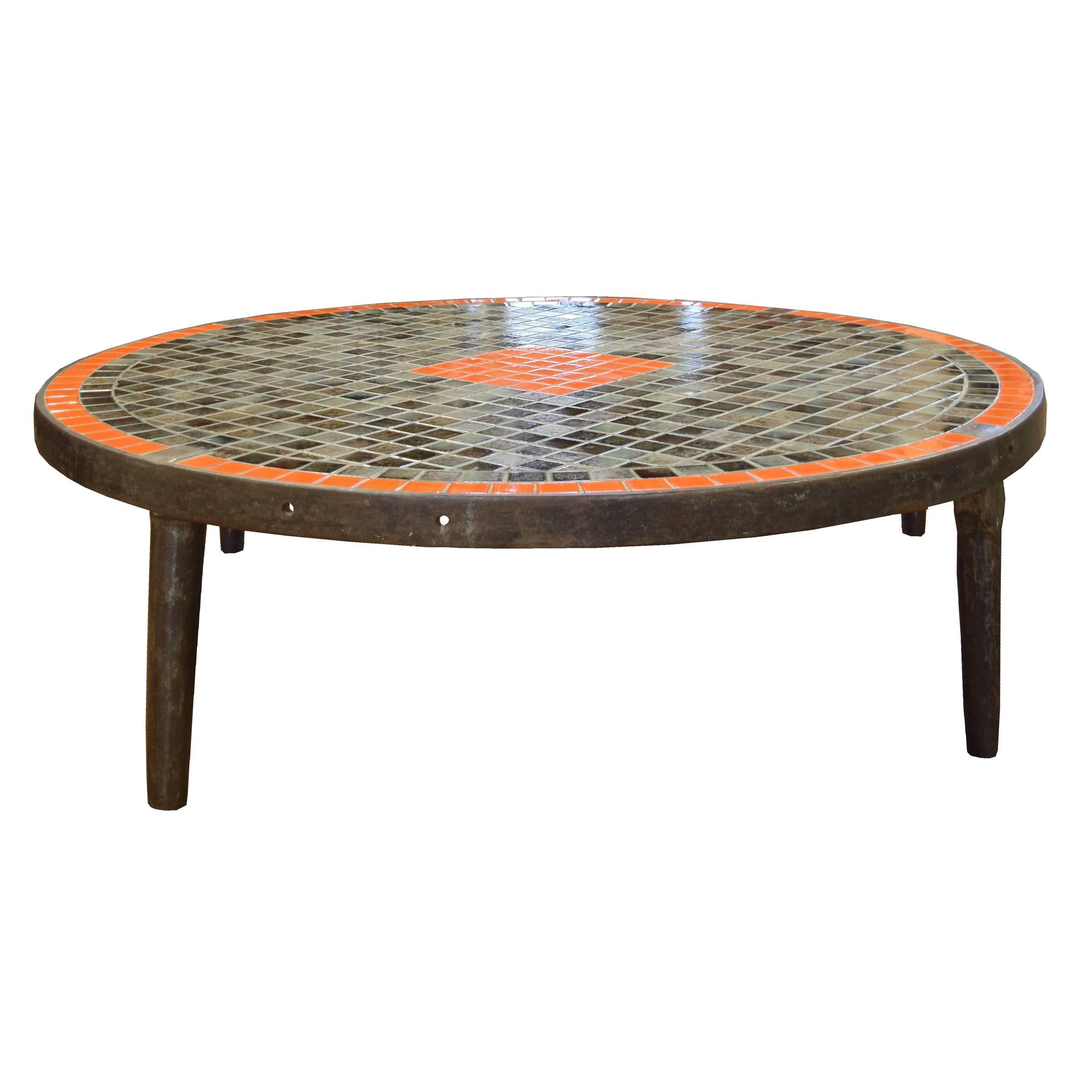 A fantastic midcentury round coffee table with a mosaic tile top and an iron base, circa 1960.