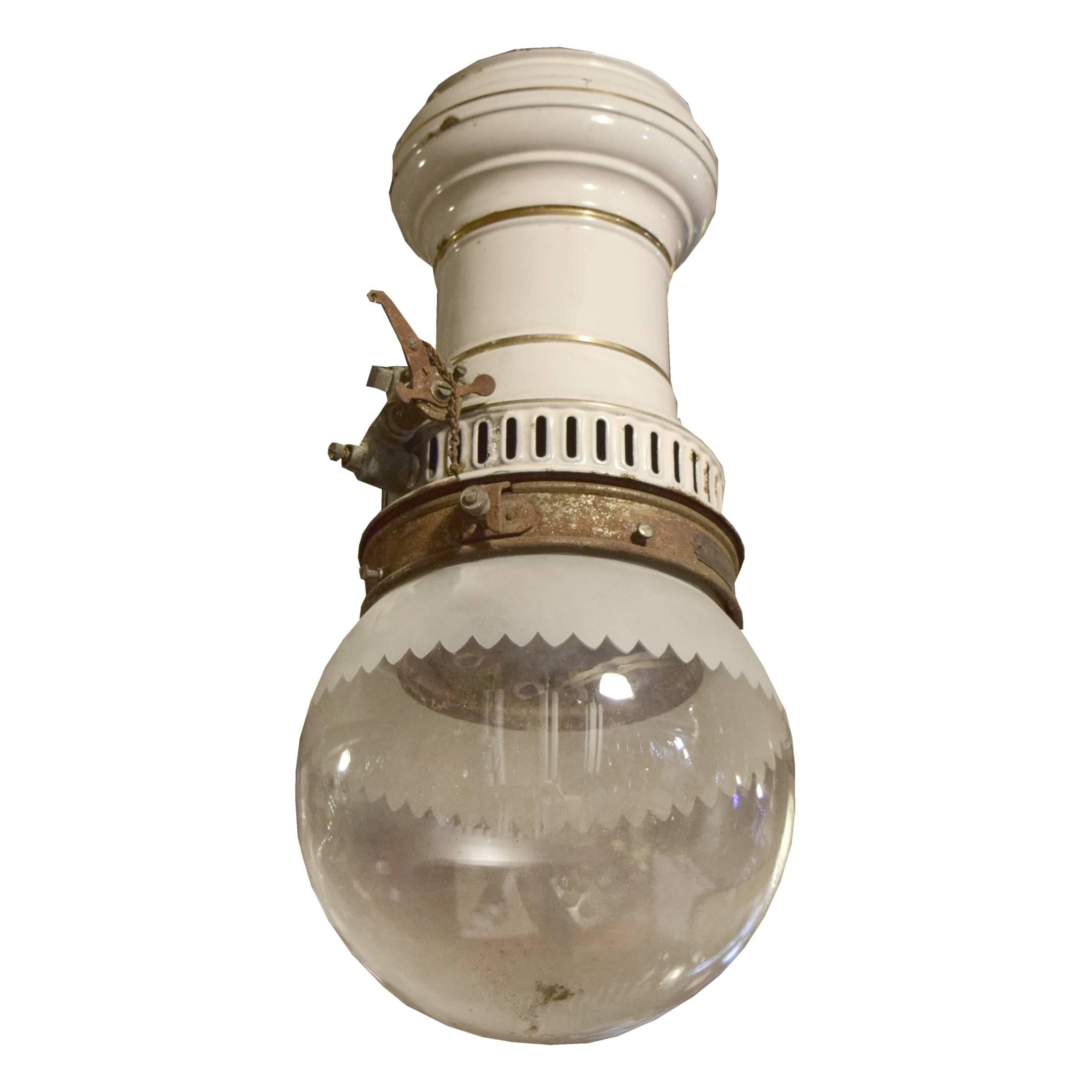 A fun Humphrey Inverted Arc lamp manufactured by the General Gas Co. of Kalamazoo, MI with a clear glass globe with a frosted scalloped detail and an enameled body, early 20th century.