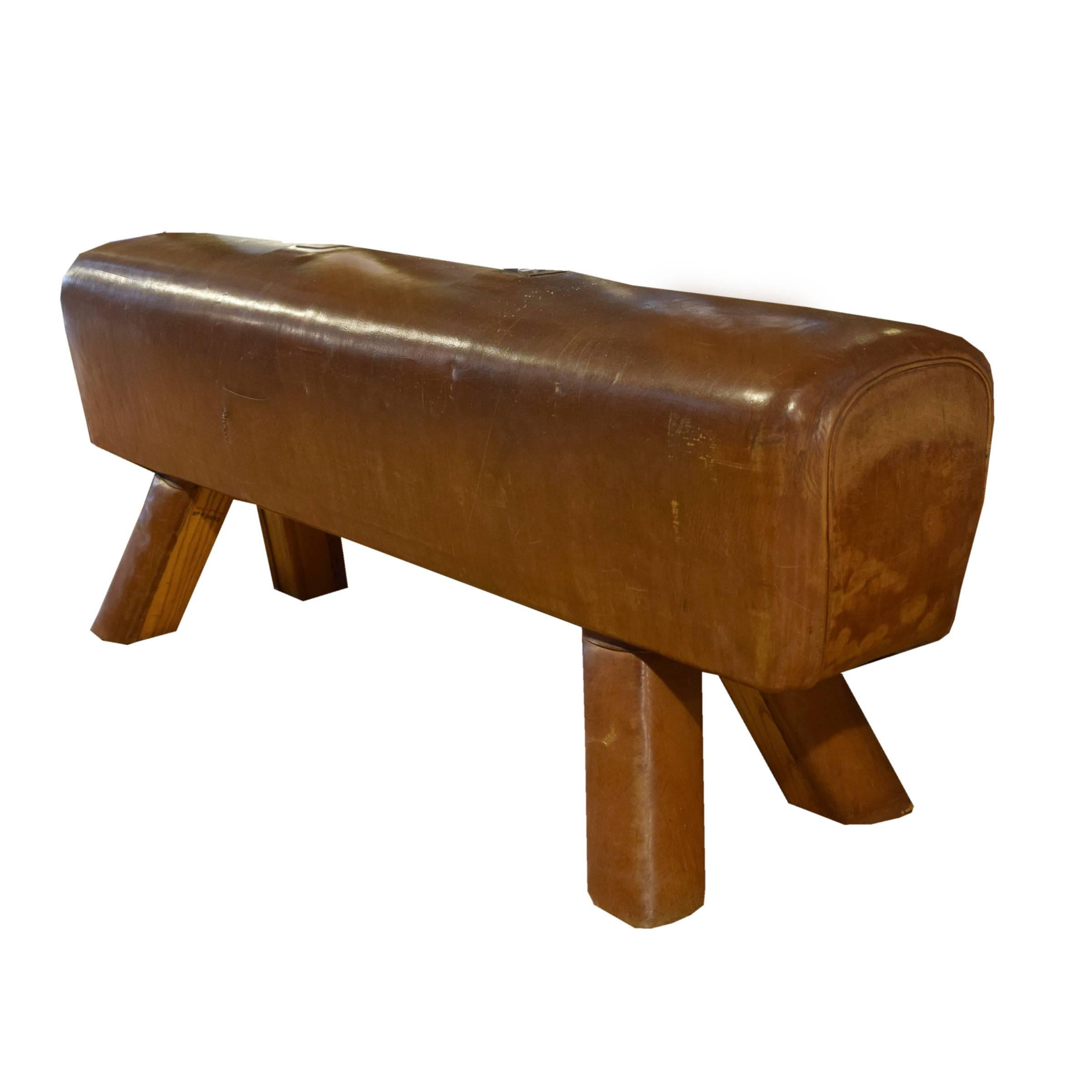 A fantastic early 20th century Czech leather pommel horse bench with leather covered wooden legs and custom steel plates covering the location of the original handles.
 