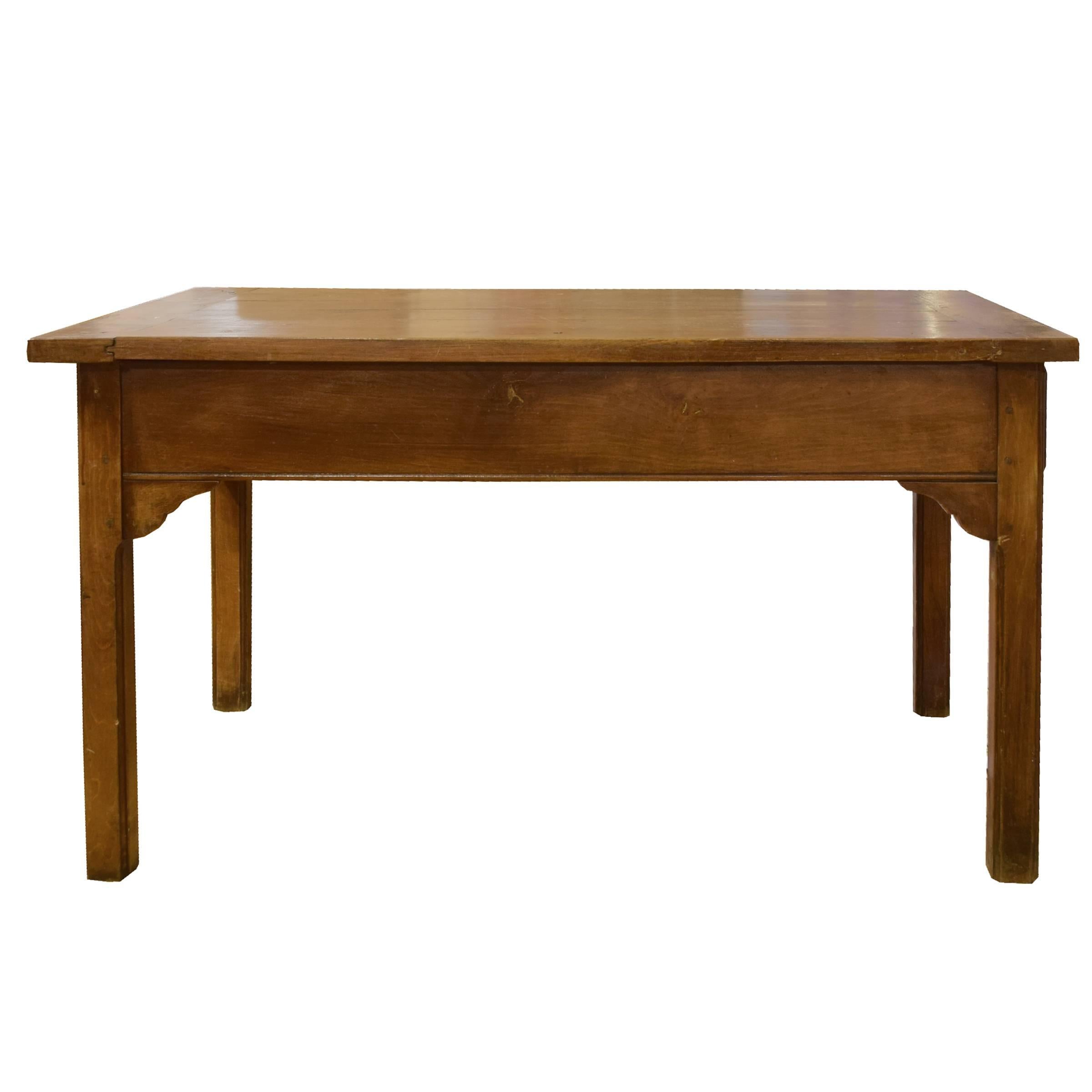 A 19th century, French walnut baker’s table with one drawer, square legs and a scroll carved apron.
  