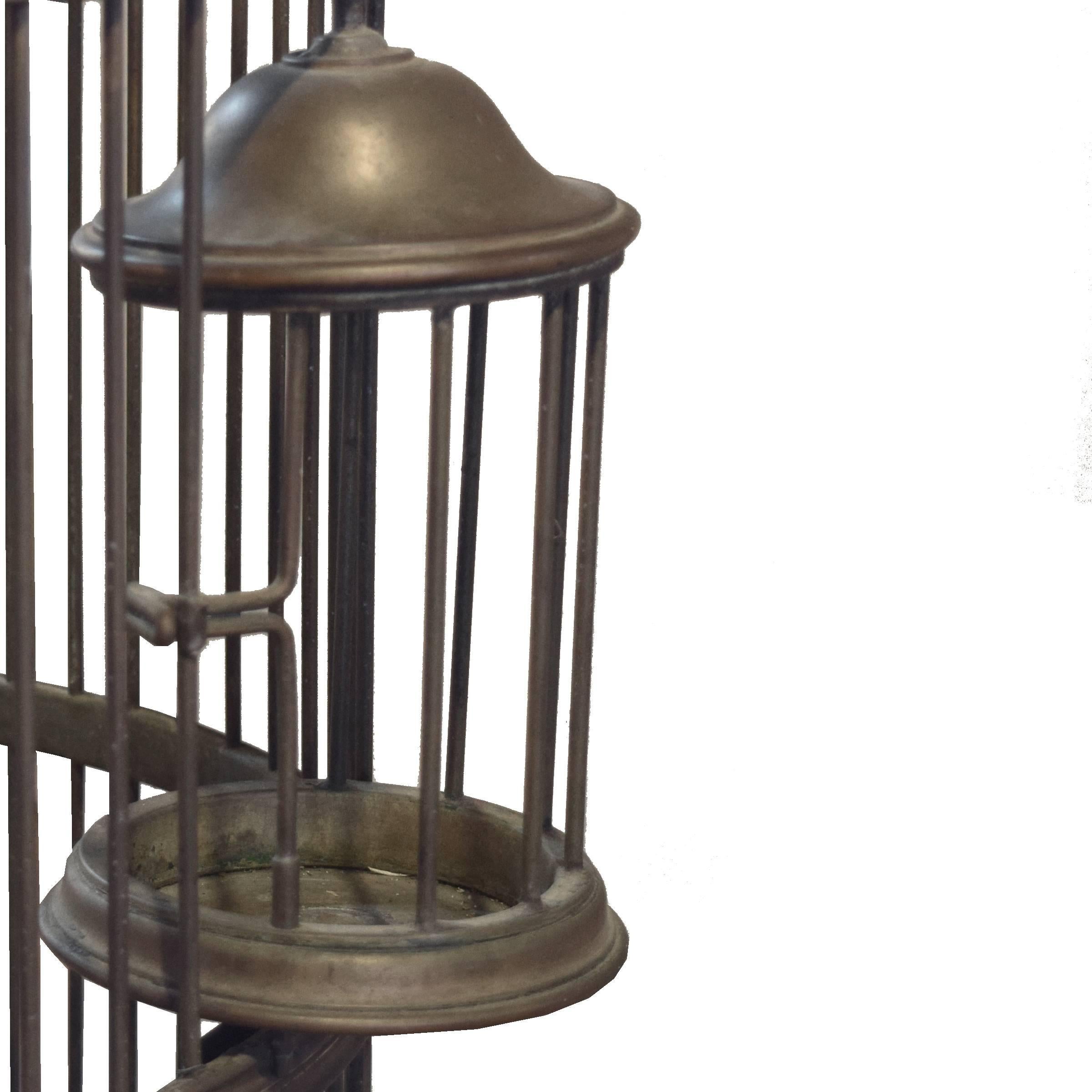 A fantastic large brass birdcage with interior and exterior perches, as well as a large main door and two rotating side doors, circa 1920.