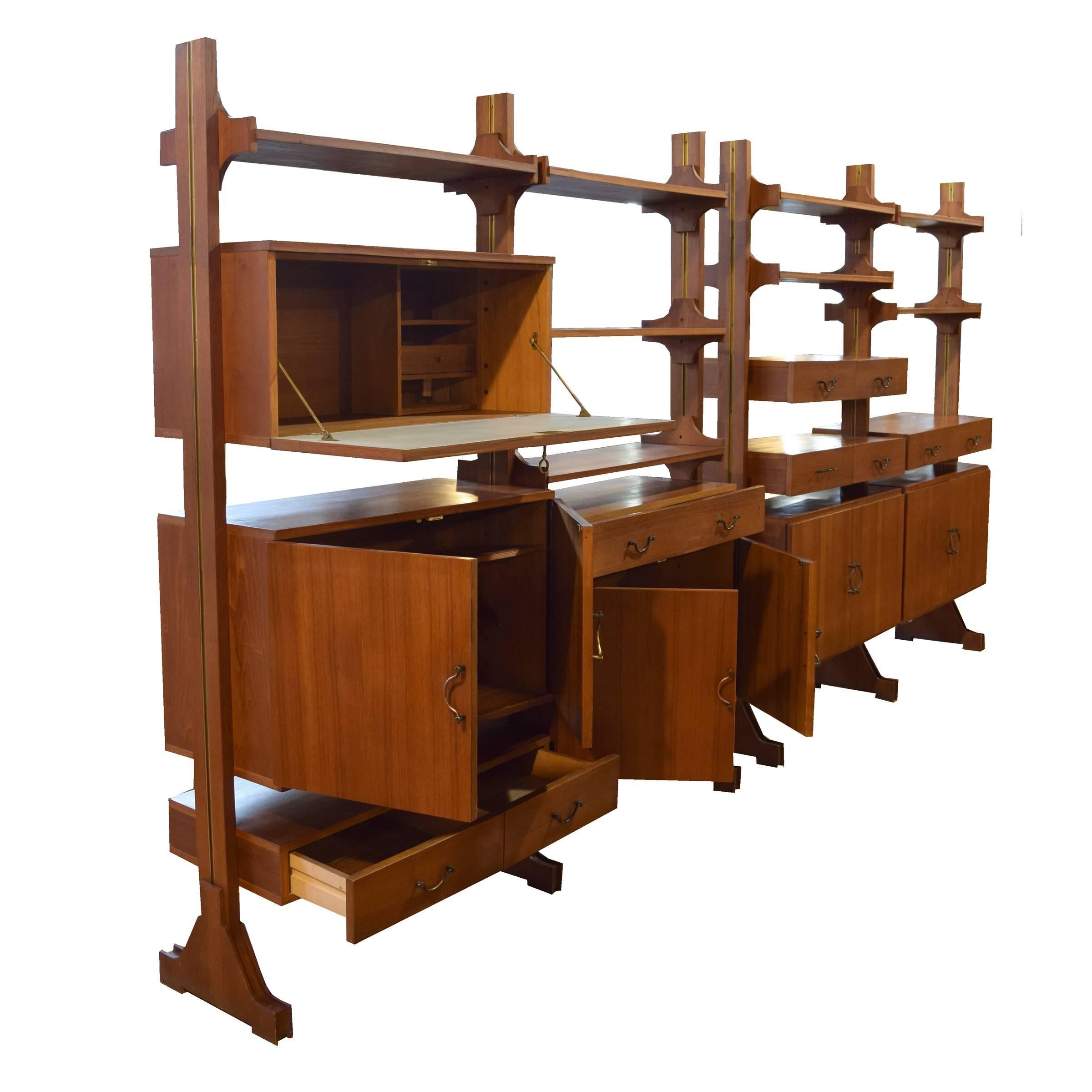An incredible Italian Modern freestanding two section wood shelving unit with adjustable cabinets, drawers and shelves, all with brass hardware, circa 1960.
Width listed is for each section.