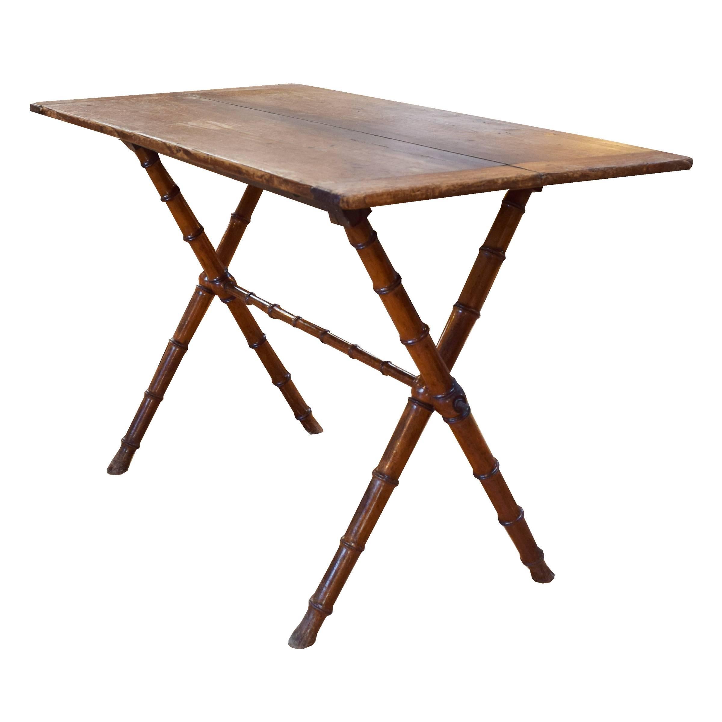 A lovely wood folding table with a pine top, four faux carved bamboo legs and stretcher, circa 1920.