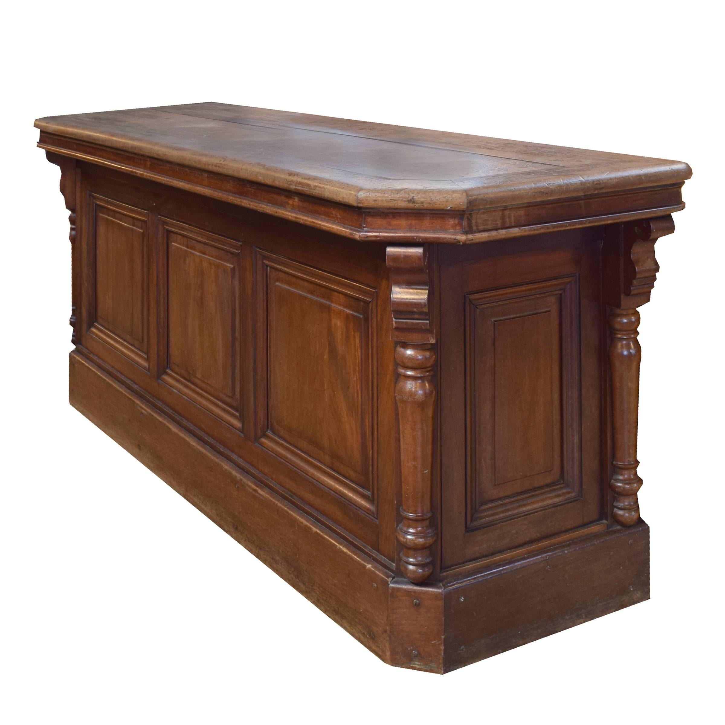 A lovely French walnut store counter with paneled front and sides and an open back, circa 1900.