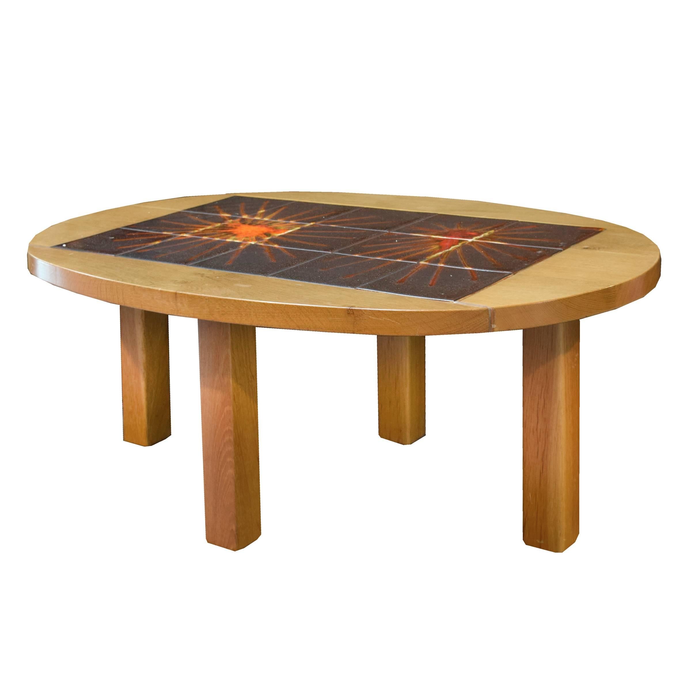 A fun oval wood coffee table with a sunburst or wheel patterned tile top by Vallarius pottery. Signed La Roue (the wheel), Vallarius. Circa 1960.
