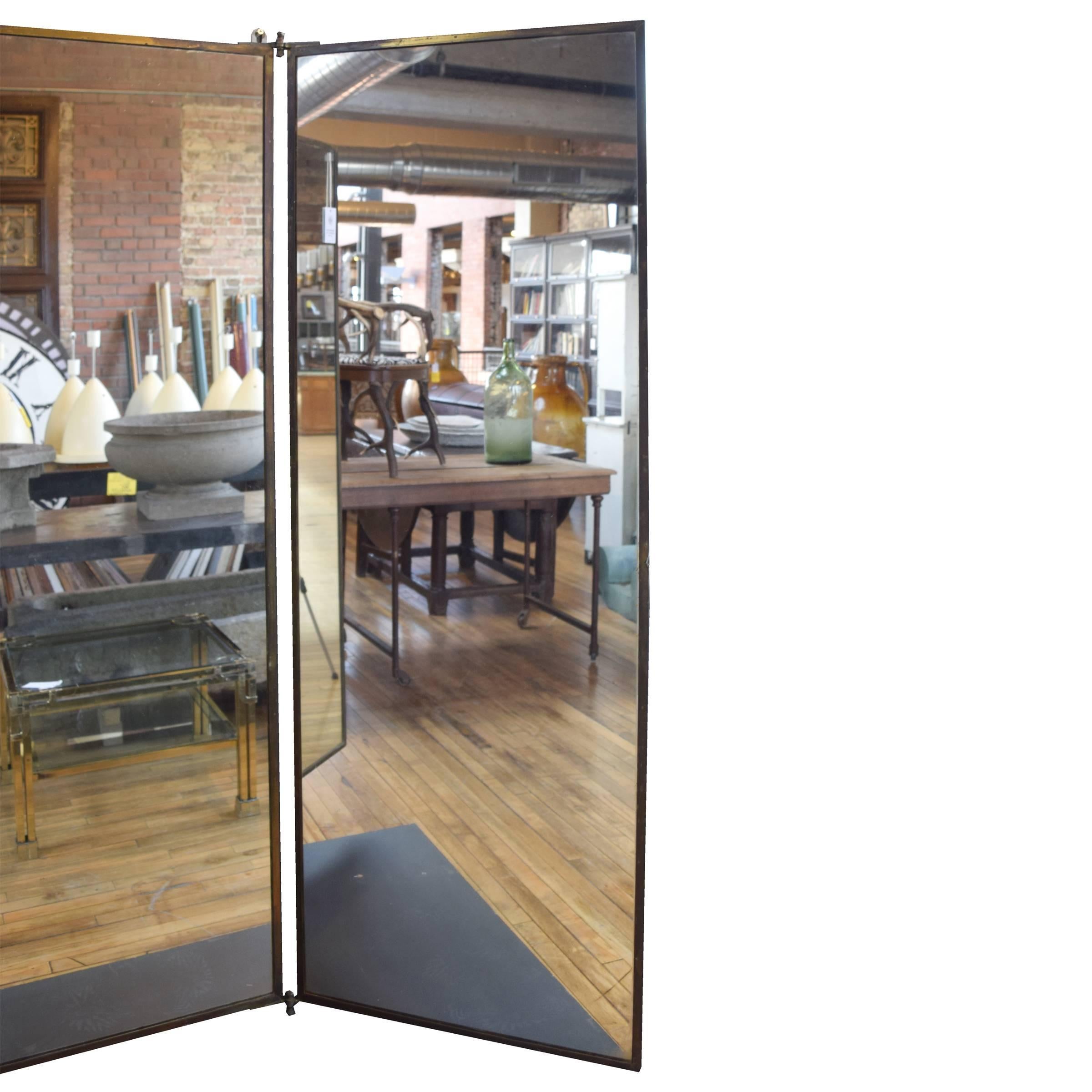 A lovely French three panel wall mounted dressing mirror with a brass frame from a dress maker's shop in Paris, circa 1920.