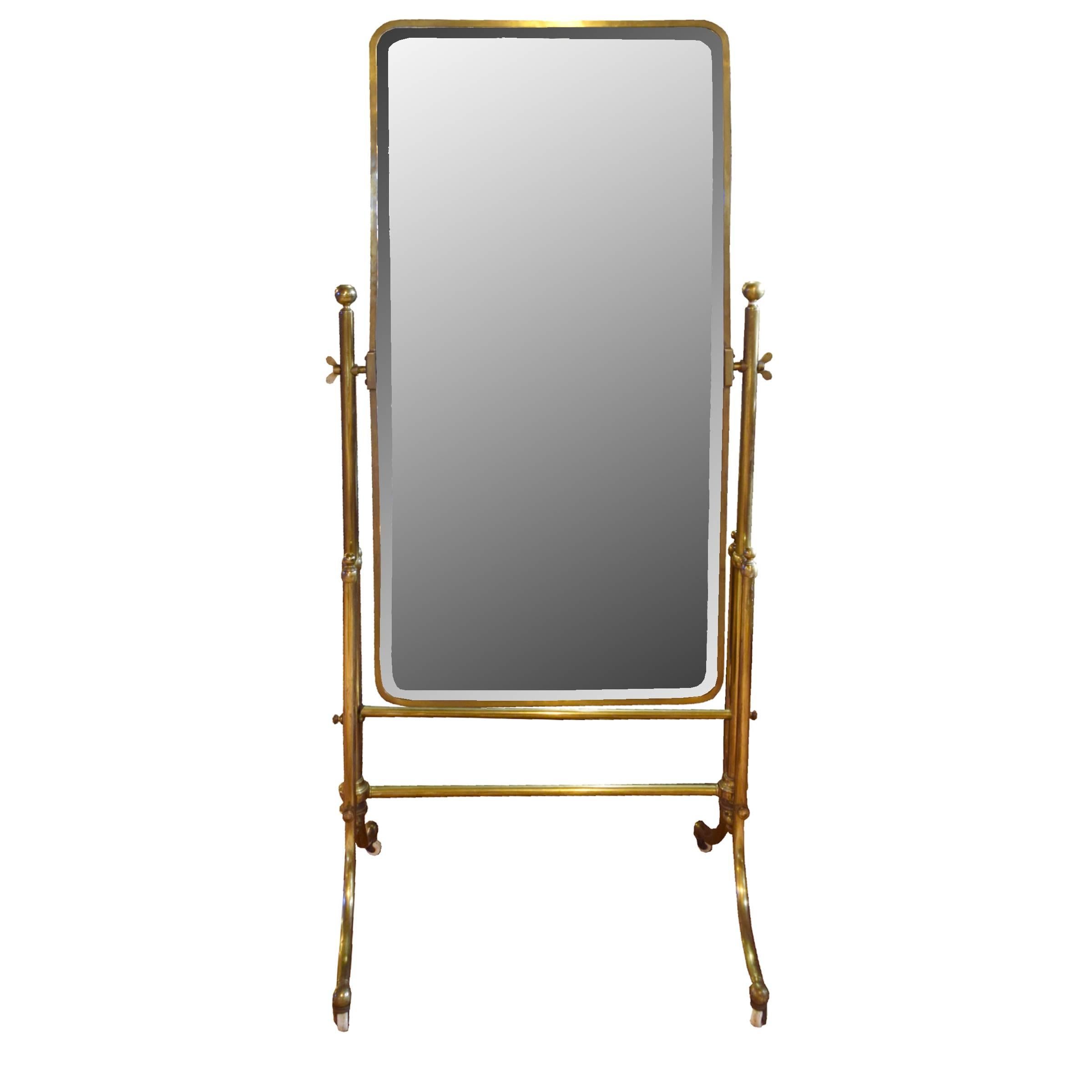 A very nice pivoting French brass dressing mirror with beveled glass with rounded corners and four legs on porcelain wheels, circa 1900.