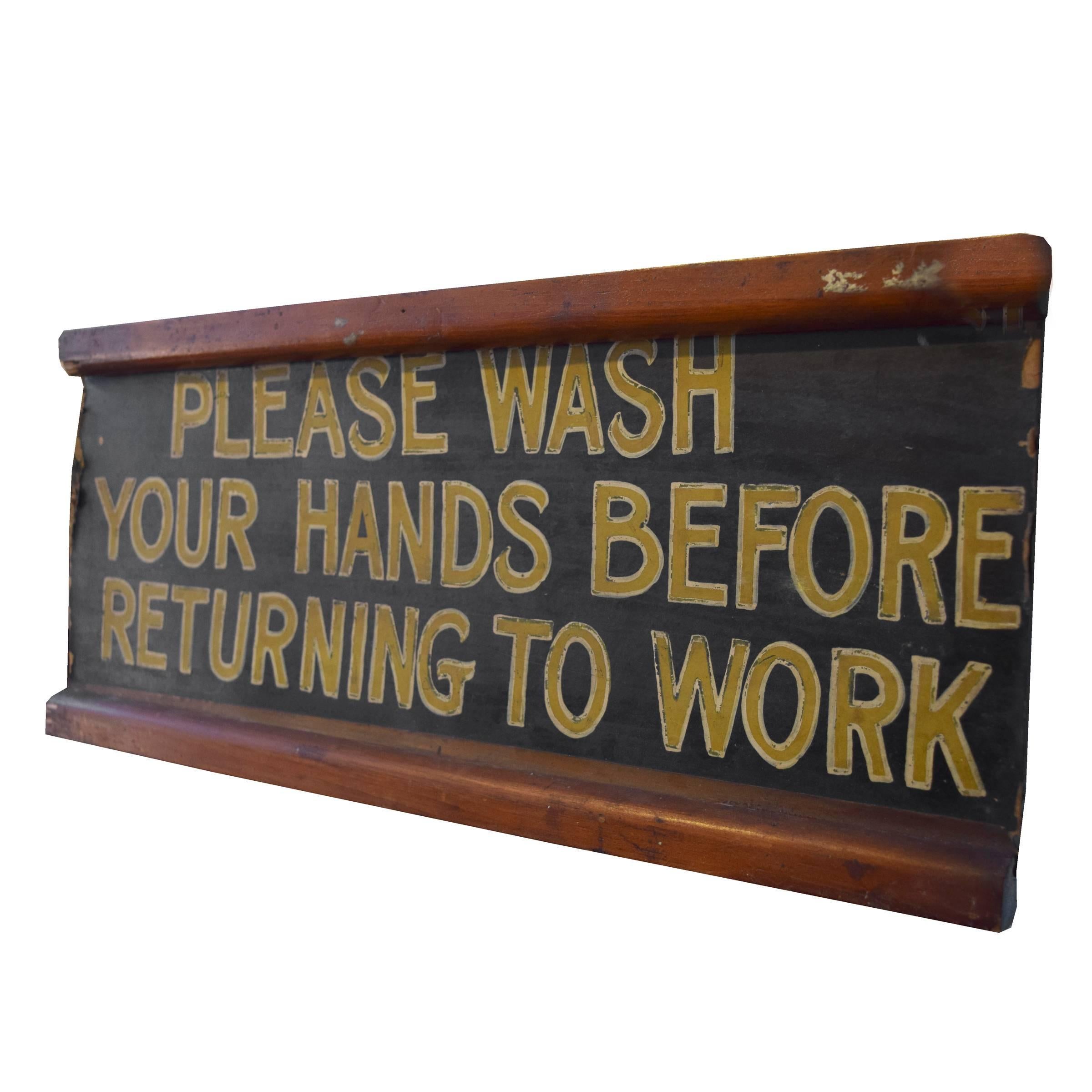 A fun wood bathroom sign with painted yellow letters reading, 'PLEASE WASH HANDS BEFORE RETURNING TO WORK'. 