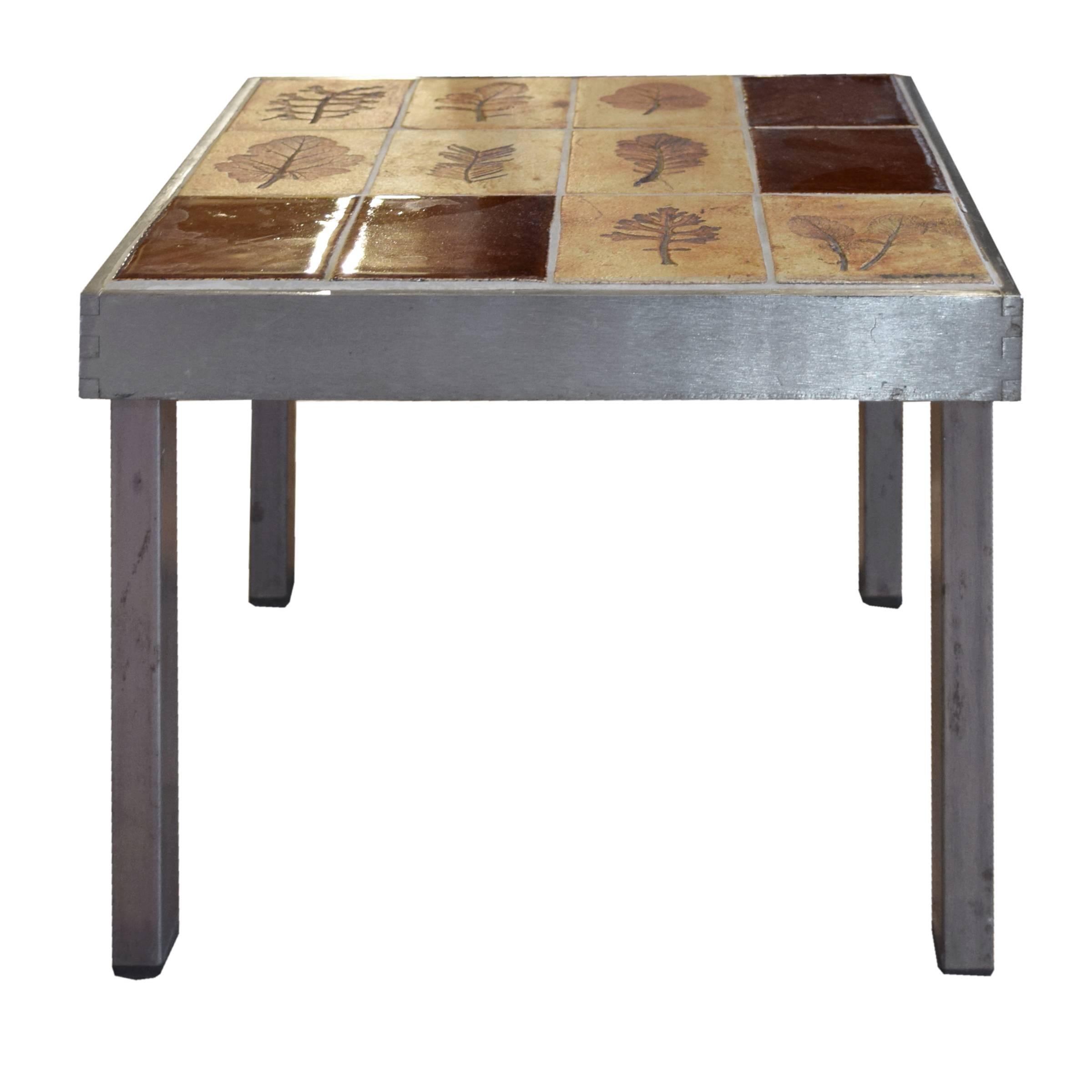 A great pair of low French tables with steel bases and tile tops with lovely leaf imprints, signed 'R. Capron'. Roger Capron (1922-2006) was an accomplished French ceramist winning many awards in his career including Gold Medal at the Brussels