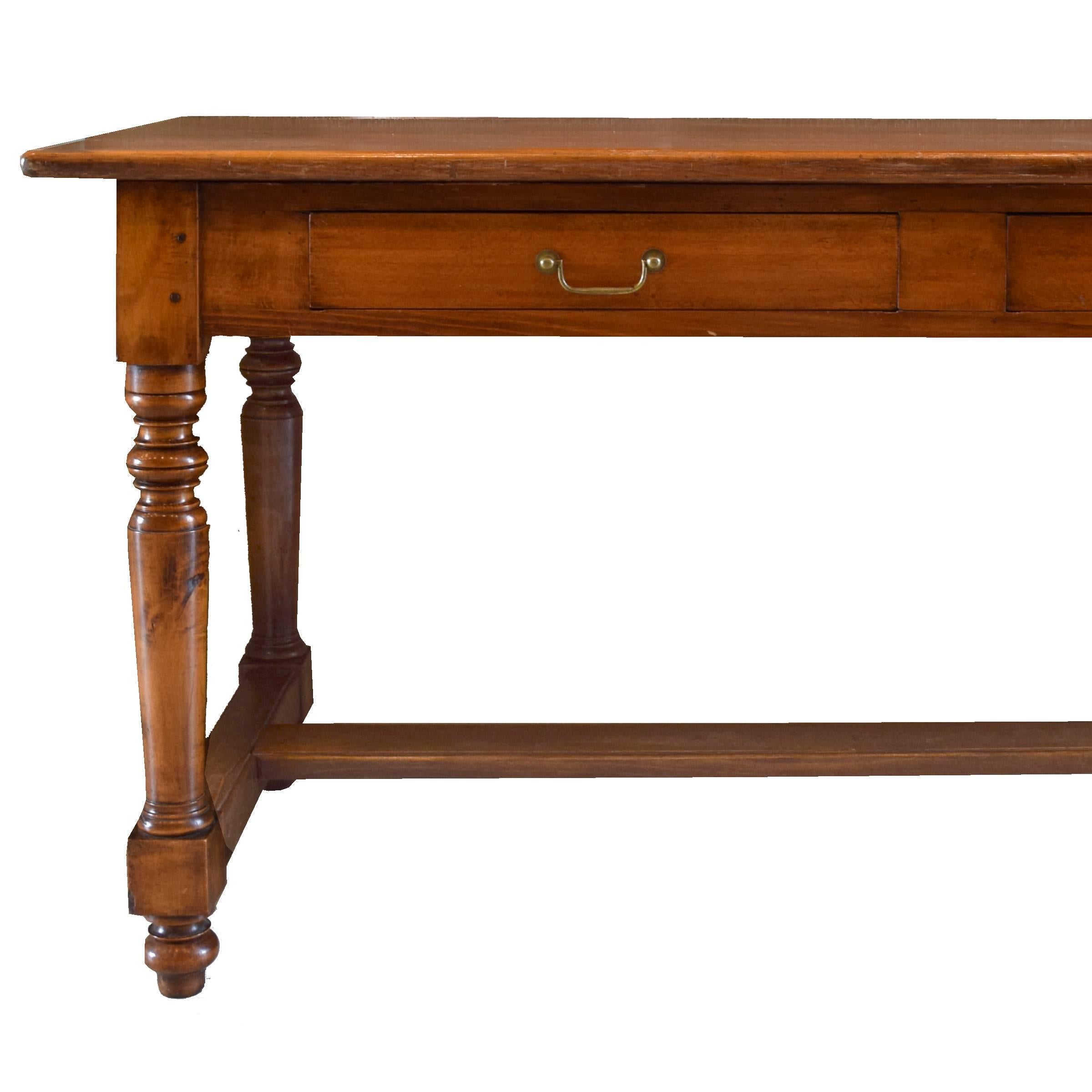 A fantastic walnut French draper's table with four drawers and six turned legs with stretchers.