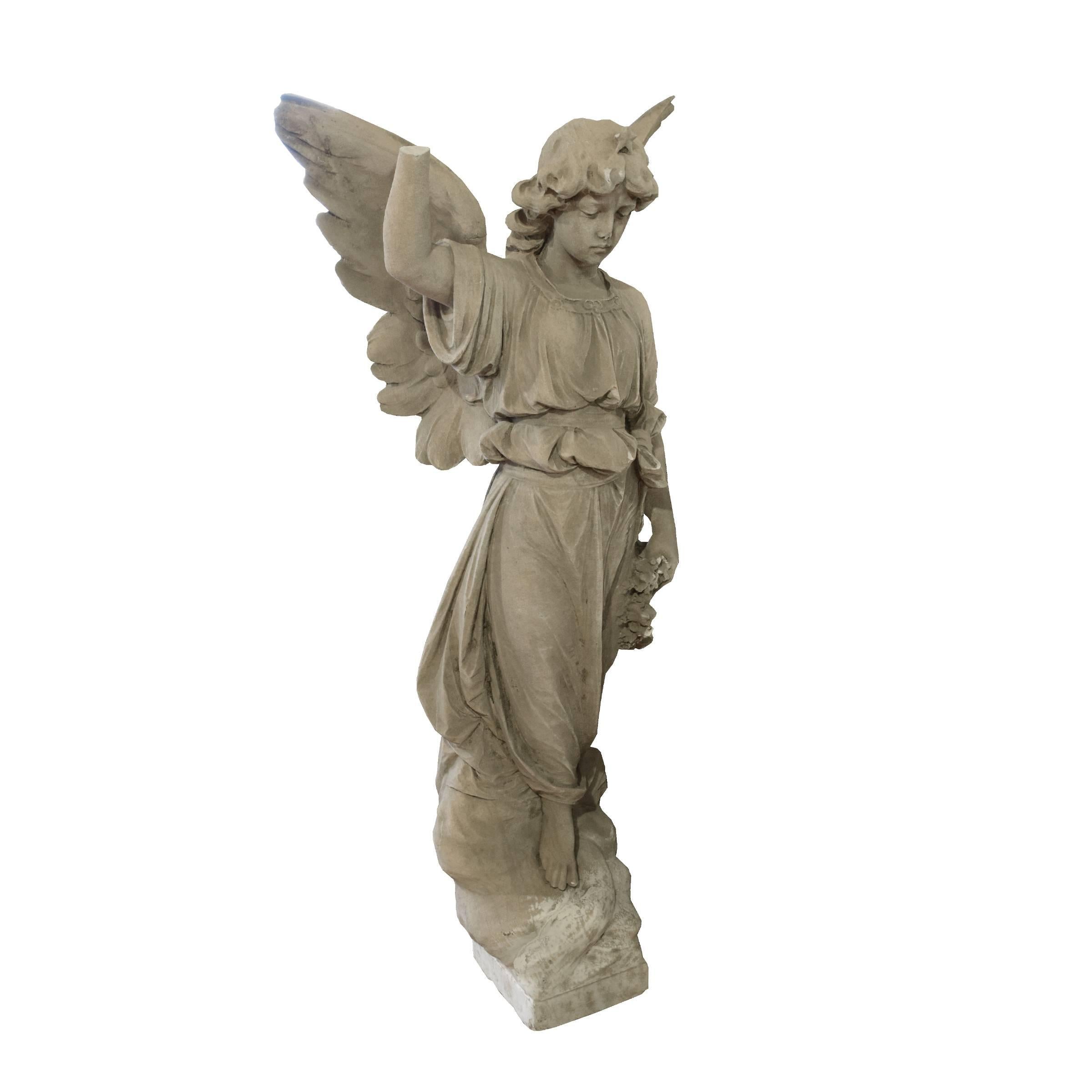 A gorgeous Italian carved marble angel with wings and holding a floral wreath, circa 1900.
