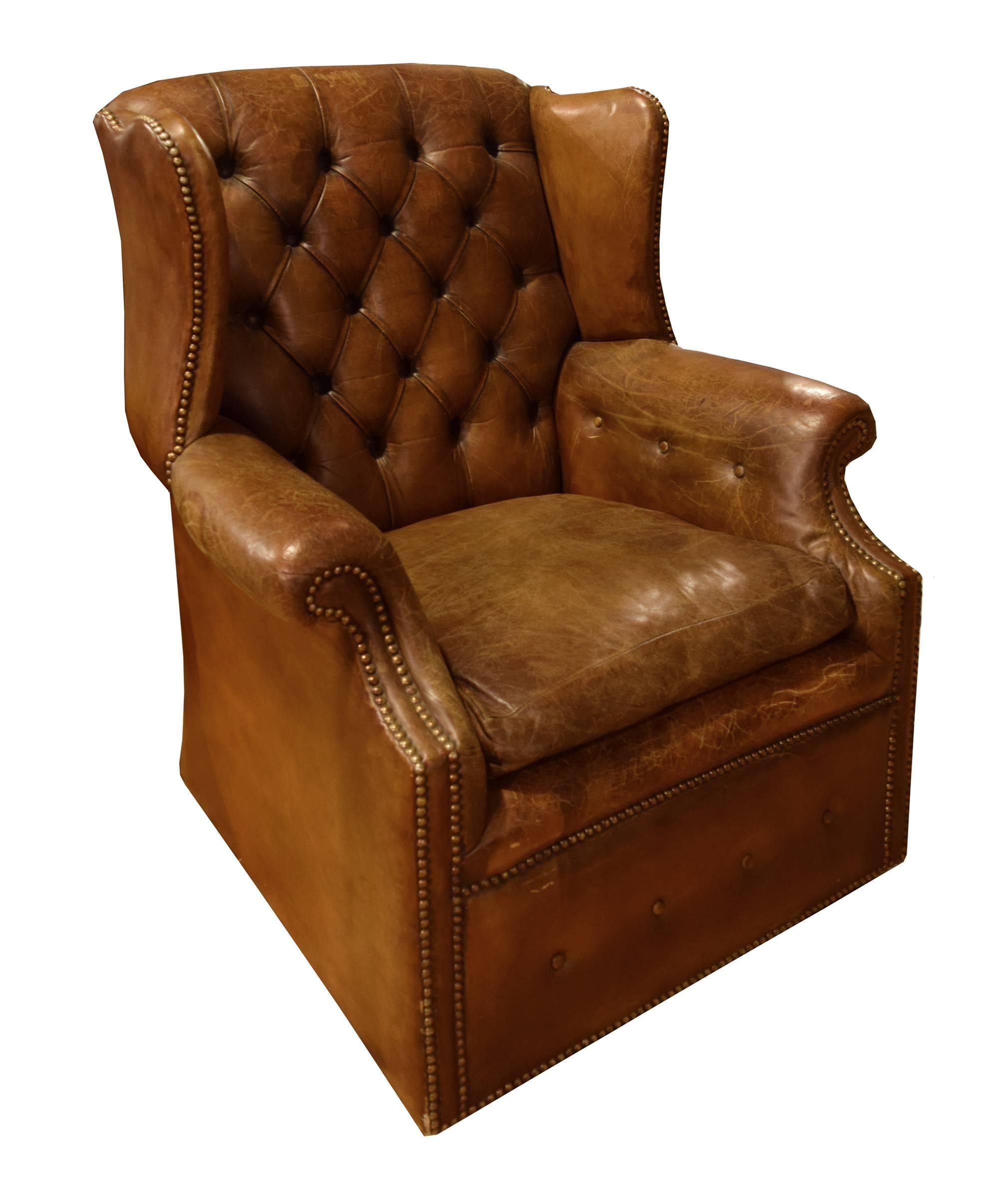 Antique tufted wingback on castors chair from Italy. This chair possesses beautifully worn original Italian leather, gently curved arms and fabulous studded detailing.