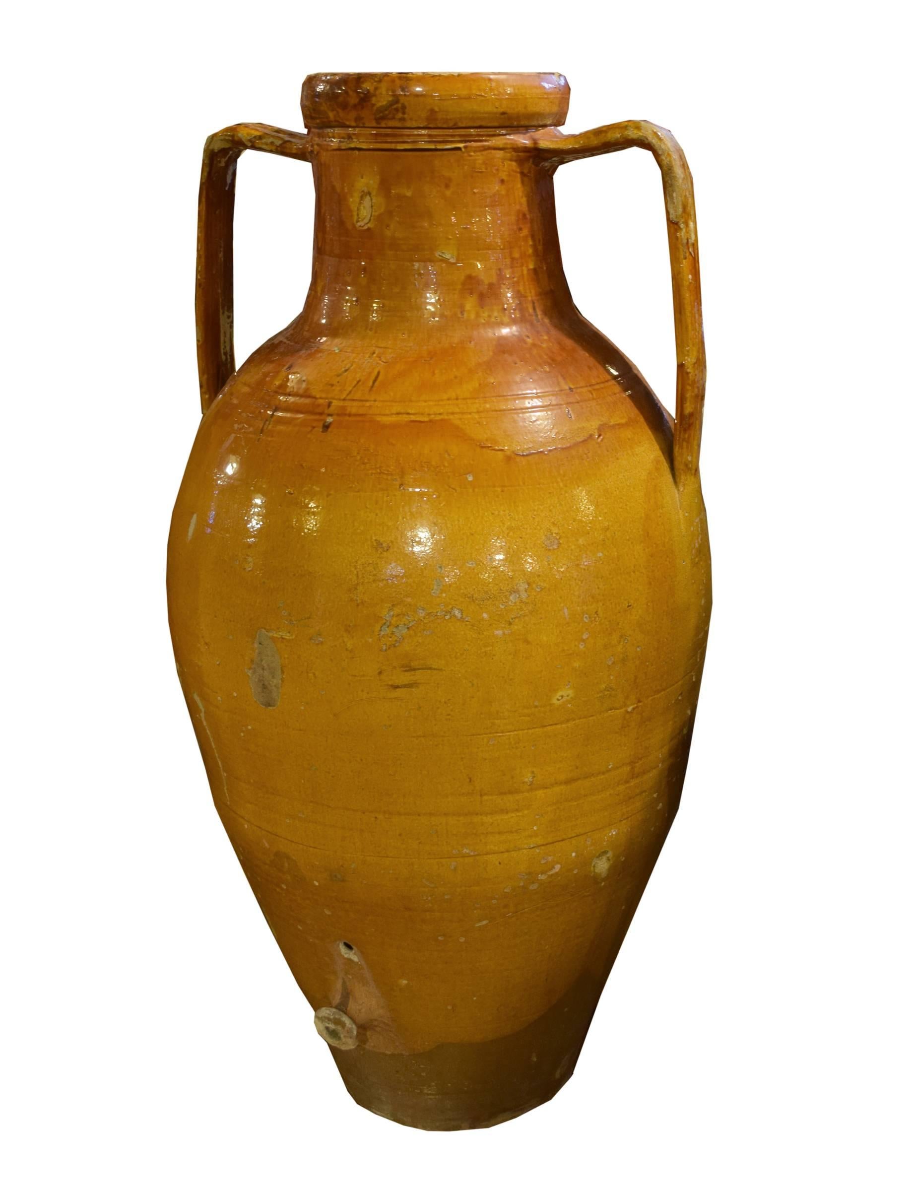 A rare 19th century terracotta olive oil jug from Italy. This jug has two sturdy handles, a beautiful glaze, and a spout at the bottom.