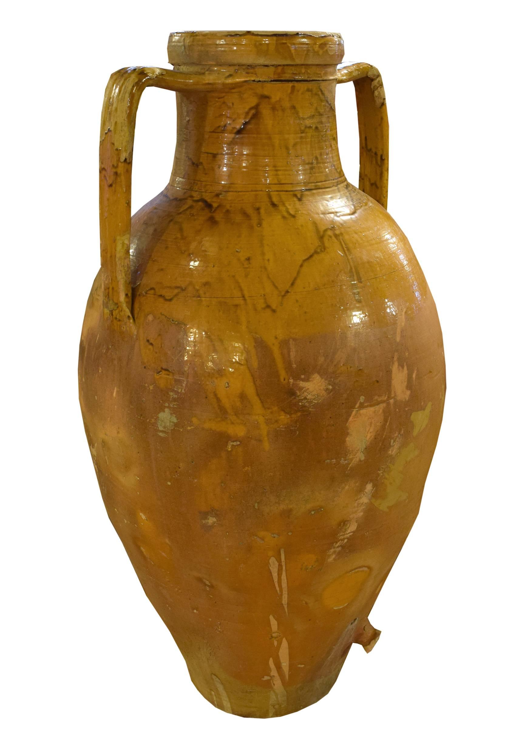 A rare 19th century terracotta olive oil jug from Italy. This jug has two sturdy handles, a beautiful glaze and a spout at the bottom.

Three others available as well.
 