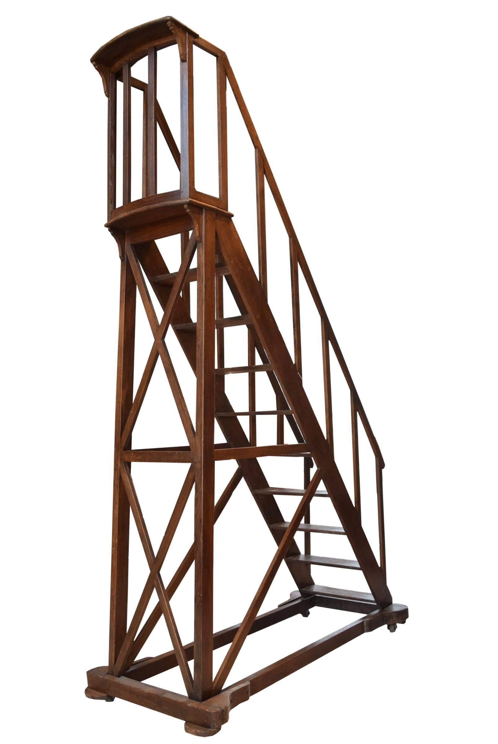 A tall ten-step library ladder on castors from France. This rare 19th century ladder has handrails along the sides as well as a tall railing at the top. The top step is 7.5 feet tall.