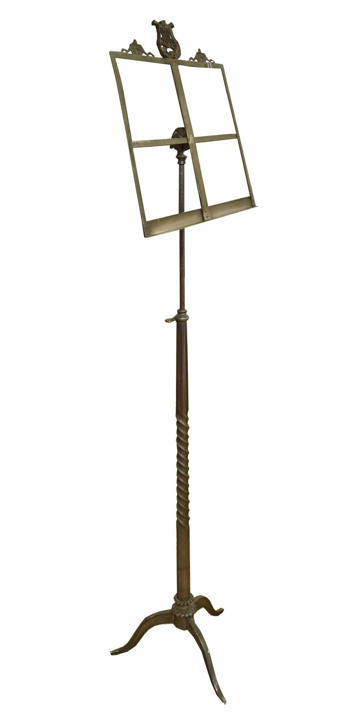 An early 20th century adjustable music stand from Italy. This bronze music stand features a tapered twisted shaft and a harp shaped finial on the top. The total height of the stand adjust from 52