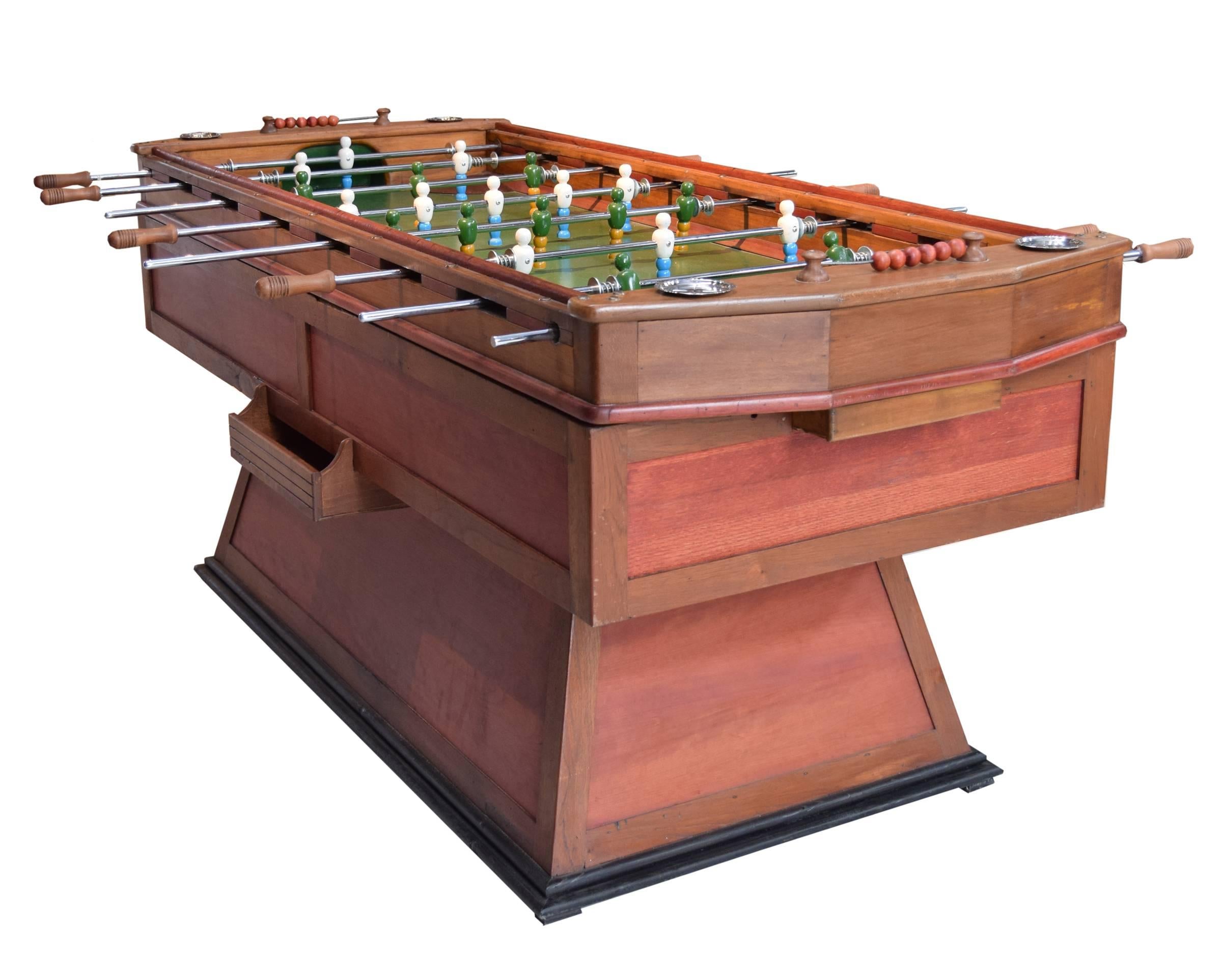 An Italian foosball table, circa 1925-1930, with an extra-long length. The coin operated table features painted wood players on metal rods that uniquely move in four directions. The table also boasts dual manual scoring systems and four ashtrays.