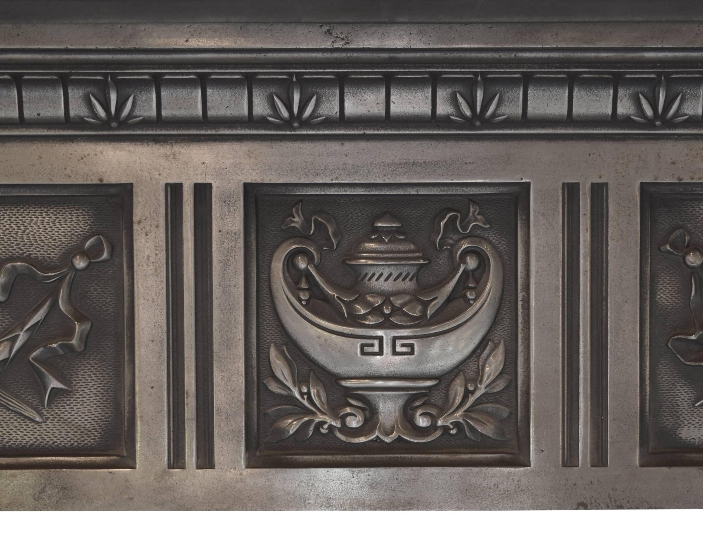 A late 19th century polished cast iron fireplace surround from England, with finely cast swallows, floral swags, sheafs of wheat, and a large lamp of knowledge. 


