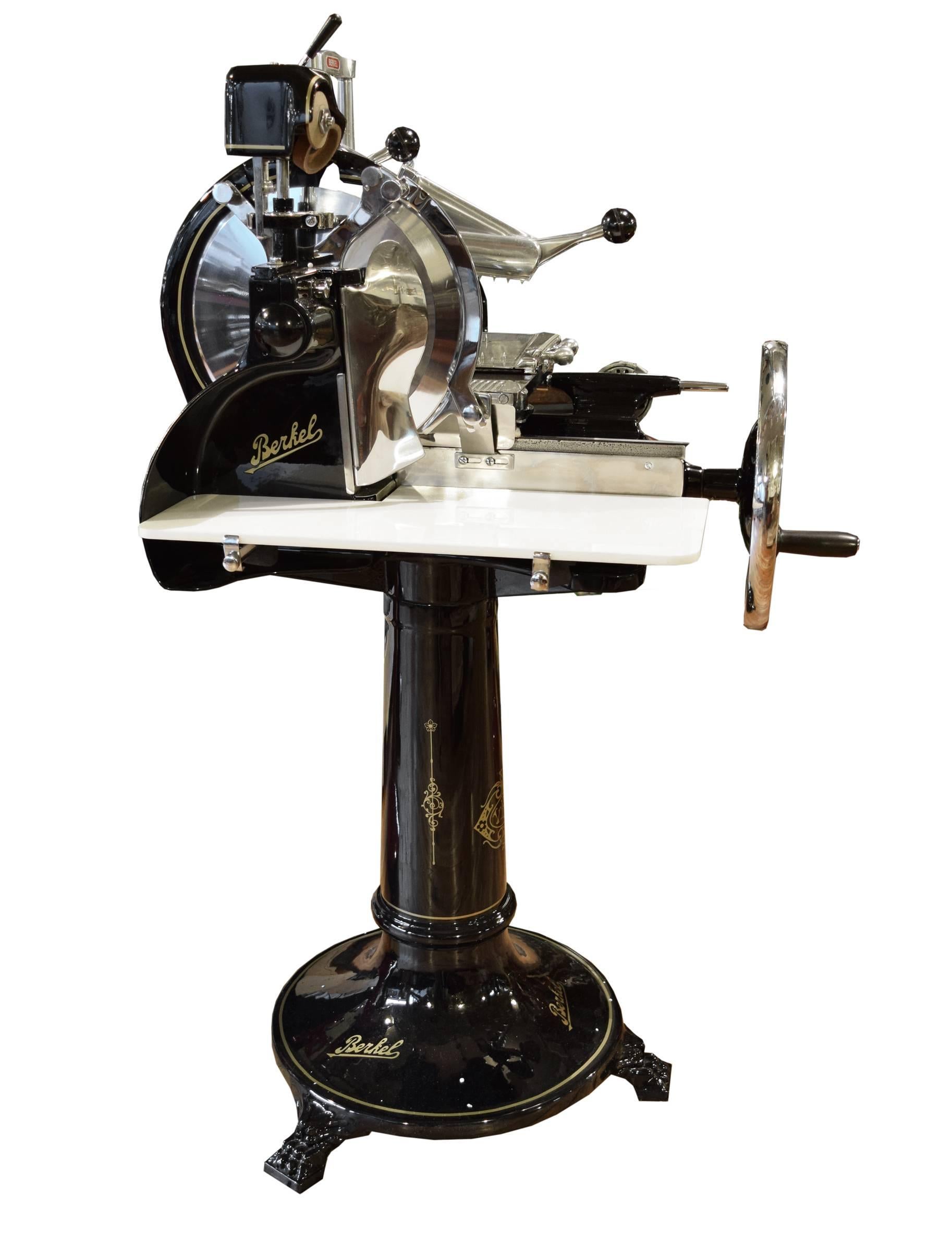 A rare Berkel model 9 meat slicer in a black high gloss enamel with gold pinstriping, manufactured in Rotterdam, Holland. This model, circa 1935, is flywheel operated and features 15 different slicing thicknesses and a blade sharpener. This slicer