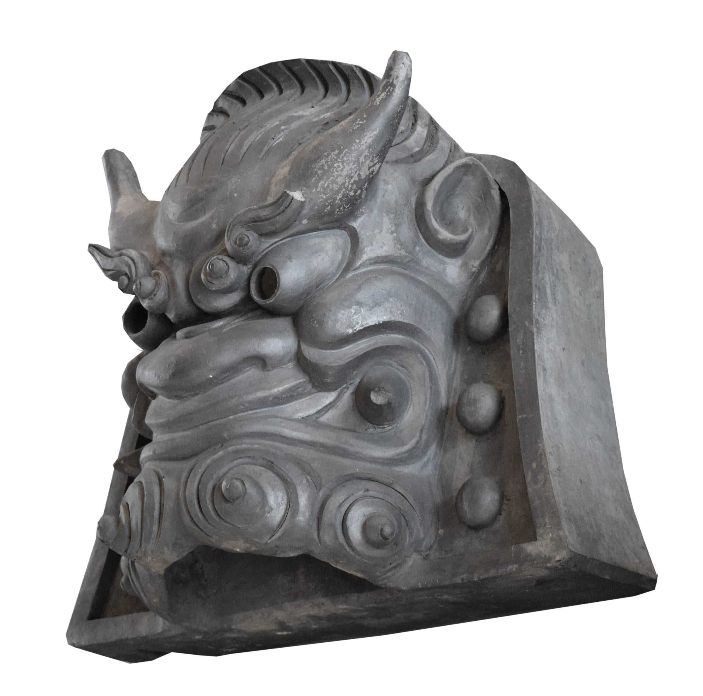 A 19th century Japanese terra cotta roof ornament depicting a temple guardian, intended to keep evil spirits at bay. On a custom wall mount.