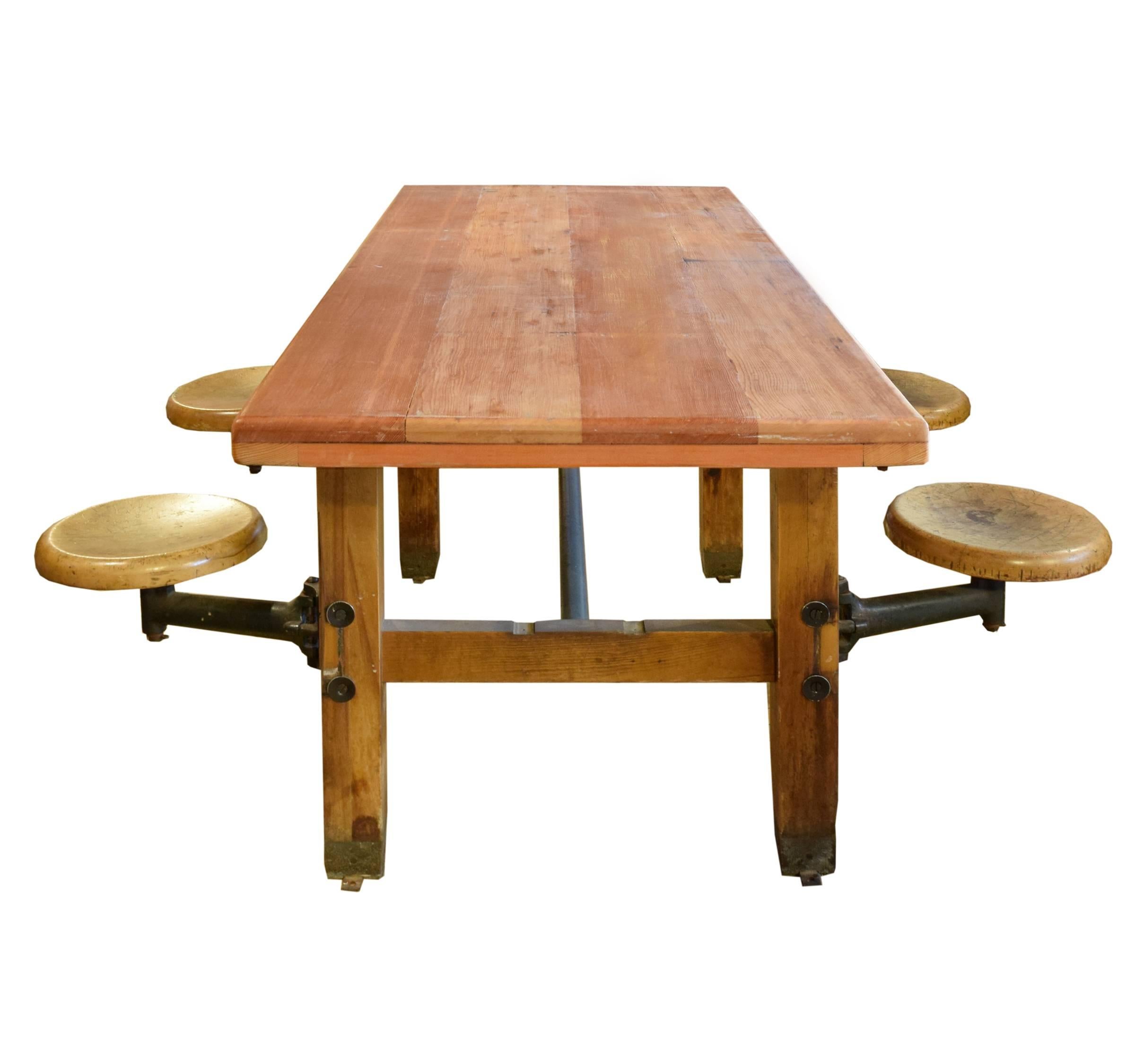 American industrial table with four iron swing arm seats from a Boston public school, with a newer top made from vintage pine.