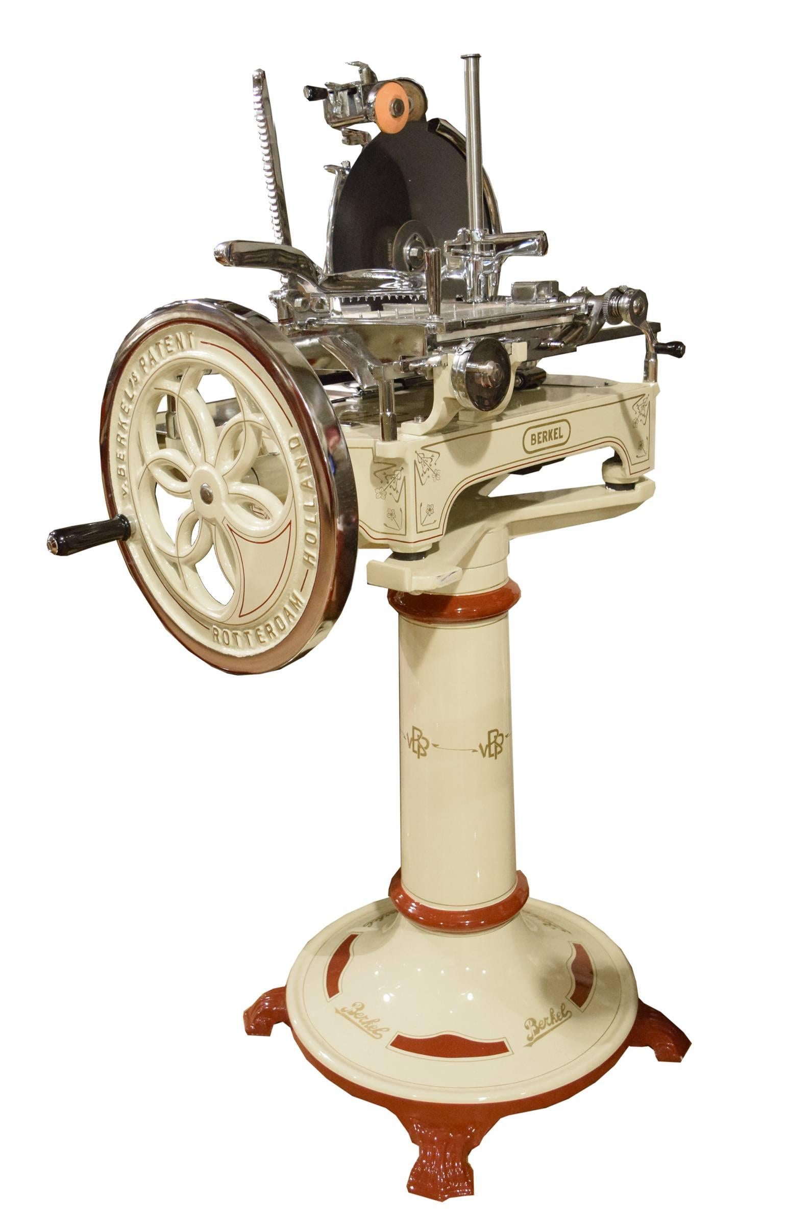 A rare Berkel Model 3 prosciutto slicing machine in a high gloss ivory enamel with red and gold pinstriping, manufactured in Rotterdam, Holland. This model, made from 1915-1924, is flywheel operated and features 15 different slicing thicknesses and