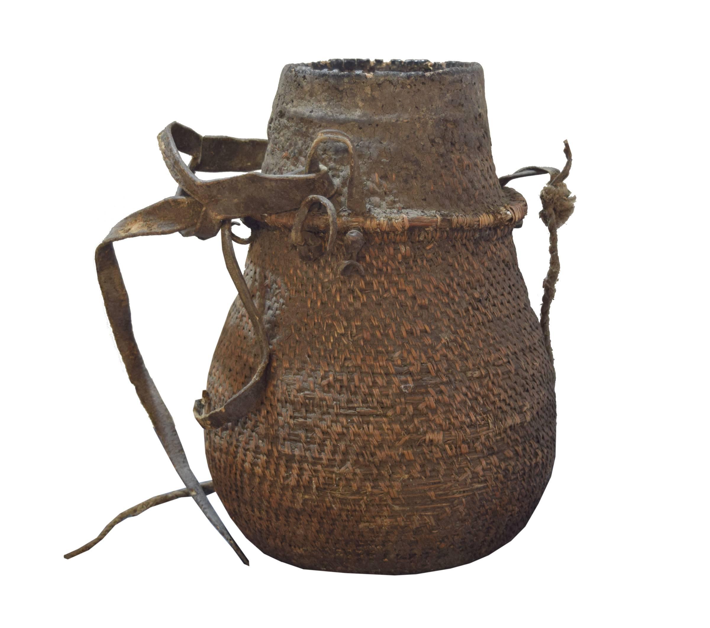 Ethiopian milk vessel with a well-worn patina, made of tightly wound fibers, leather and rope. These baskets were woven by women using fiber from the roots of various vegetable species available in the area. Used everyday to carry and preserve milk,