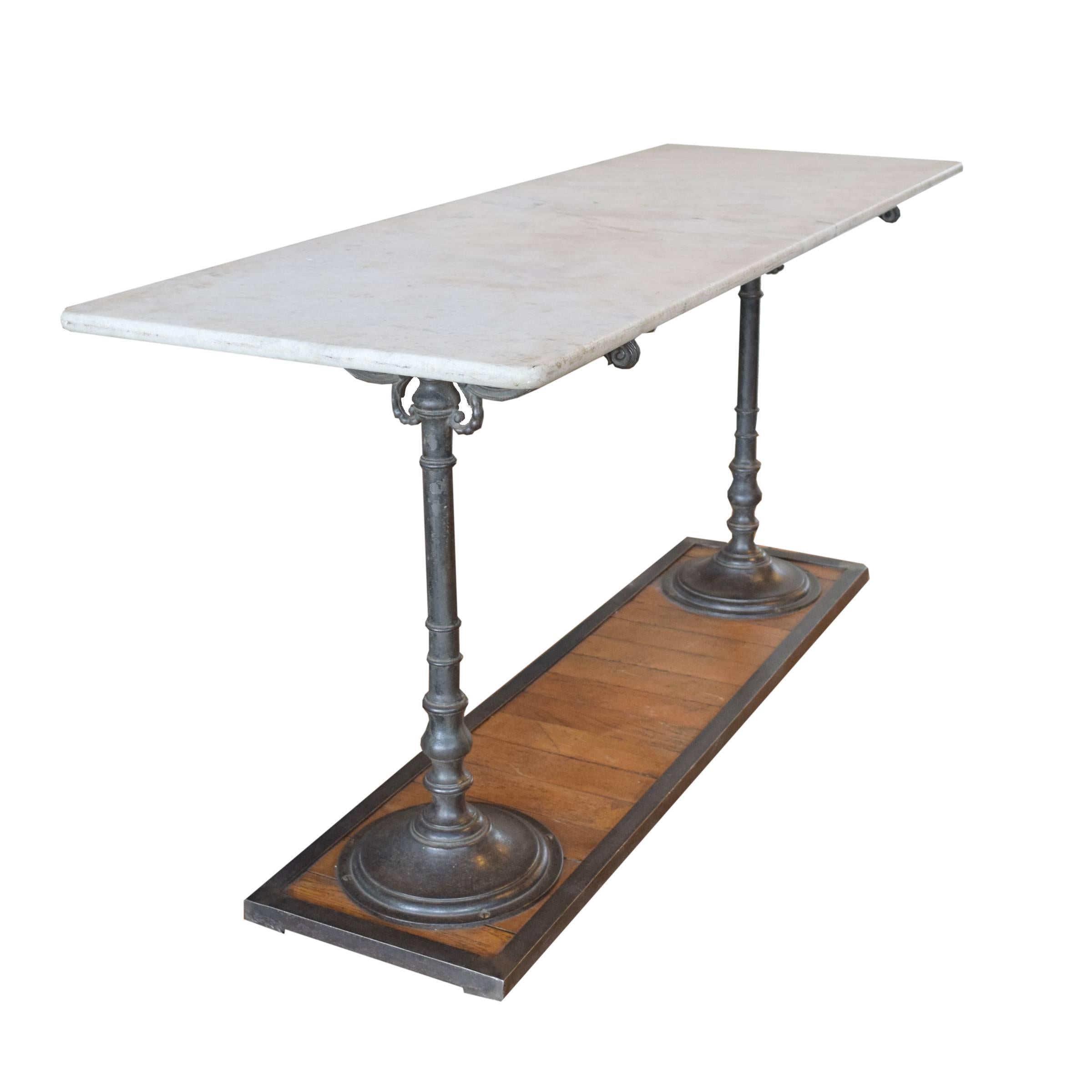 German marble-top table from a pastry shop with an iron framed slatted wood base and two iron legs, circa 1900.