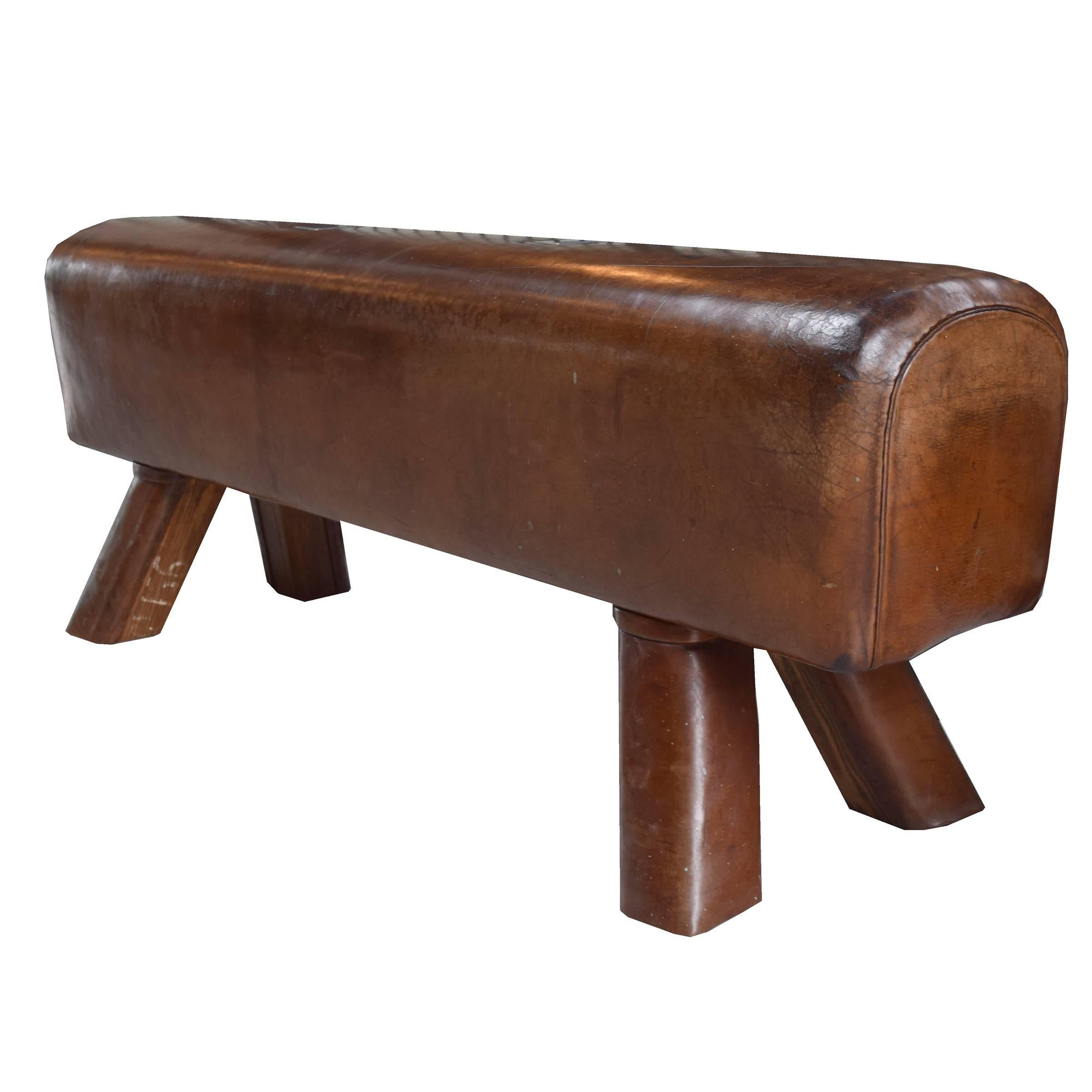 A fantastic early 20th century Czech leather pommel horse bench with leather covered wooden legs and custom steel plates covering the location of the original handles.