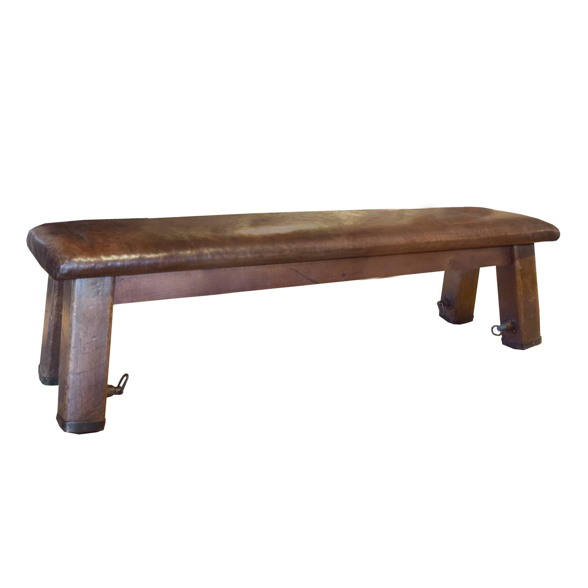 A Czech Republic wood vaulting bench with a leather top and slightly tapered square legs, circa 1930.