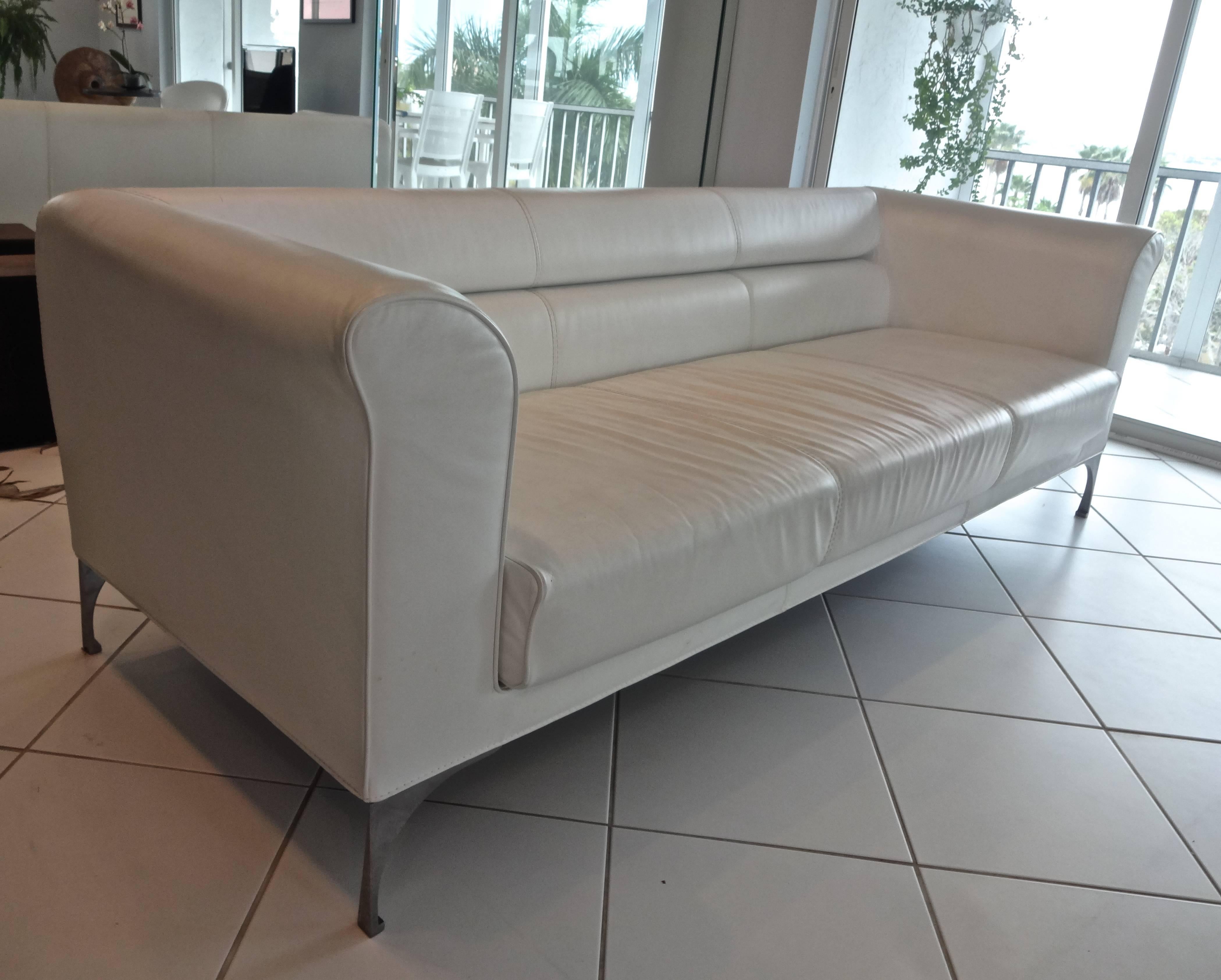 A custom modern Roche Bobois white leather three-seat sofa with polished stainless steel legs.