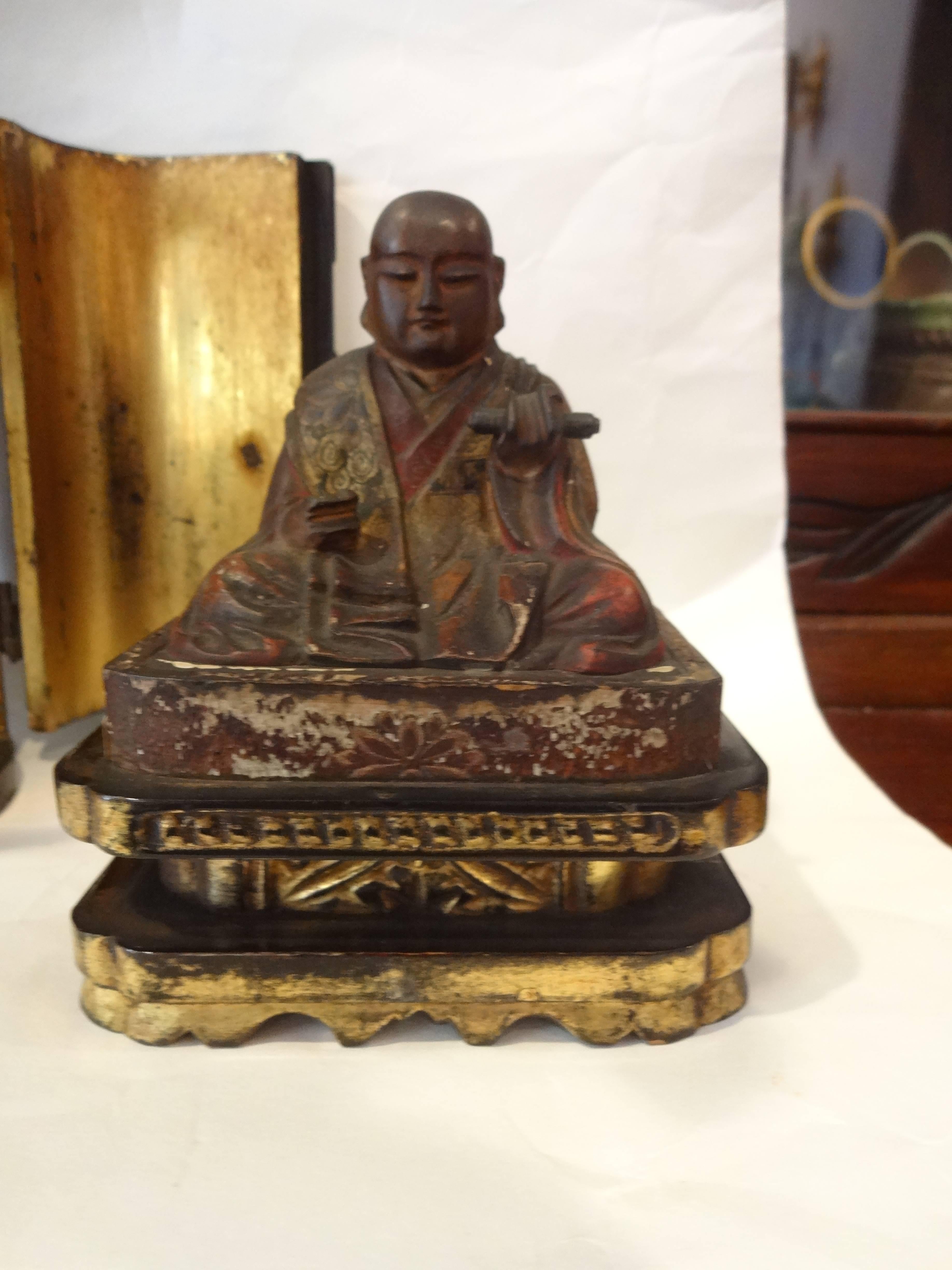 A fine Japanese Meiji period gilt and lacquered Zushi (travel shrine) with seated polychromed hand-carved wooden Buddha. Two doors open to reveal a gilt interior, centering a seated statue.
