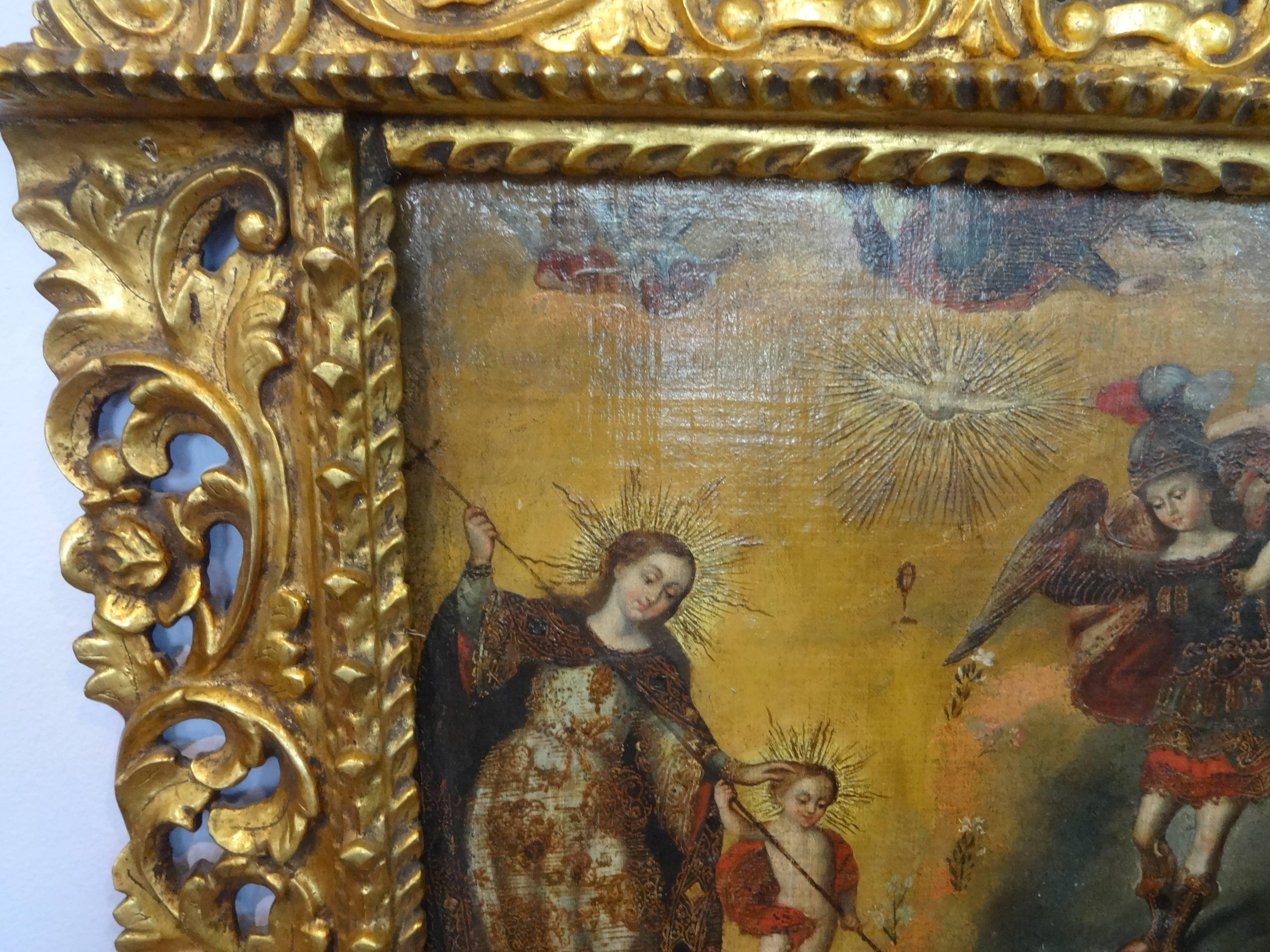 An exceptional Spanish Colonial oil painting on canvas mounted on board beautifully depicting the Virgin Mary and Jesus slaying a dragon with Saint Michael the Archangel looking on, restored, in mint condition, set in hand-carved gold leaf period