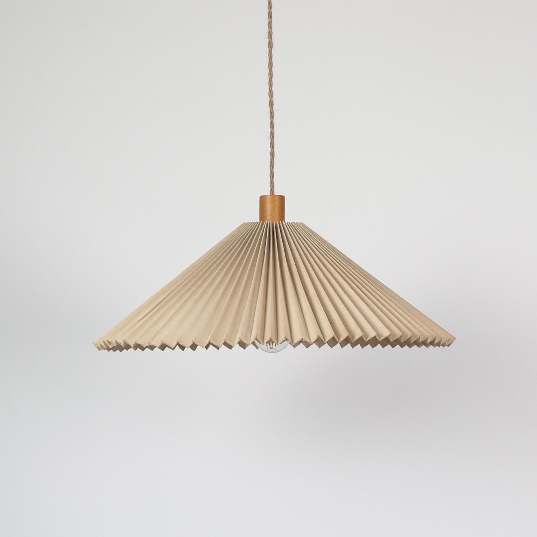 Lampada a sospensione originale Caprani realizzata da Mads Caprani negli anni '80. 

* Lampada a sospensione beige plissettata con piano in legno
* Designer: Mads Caprani
* Produttore: Caprani Light AS Danimarca 
* Anno: 1980
* Condit: Discrete