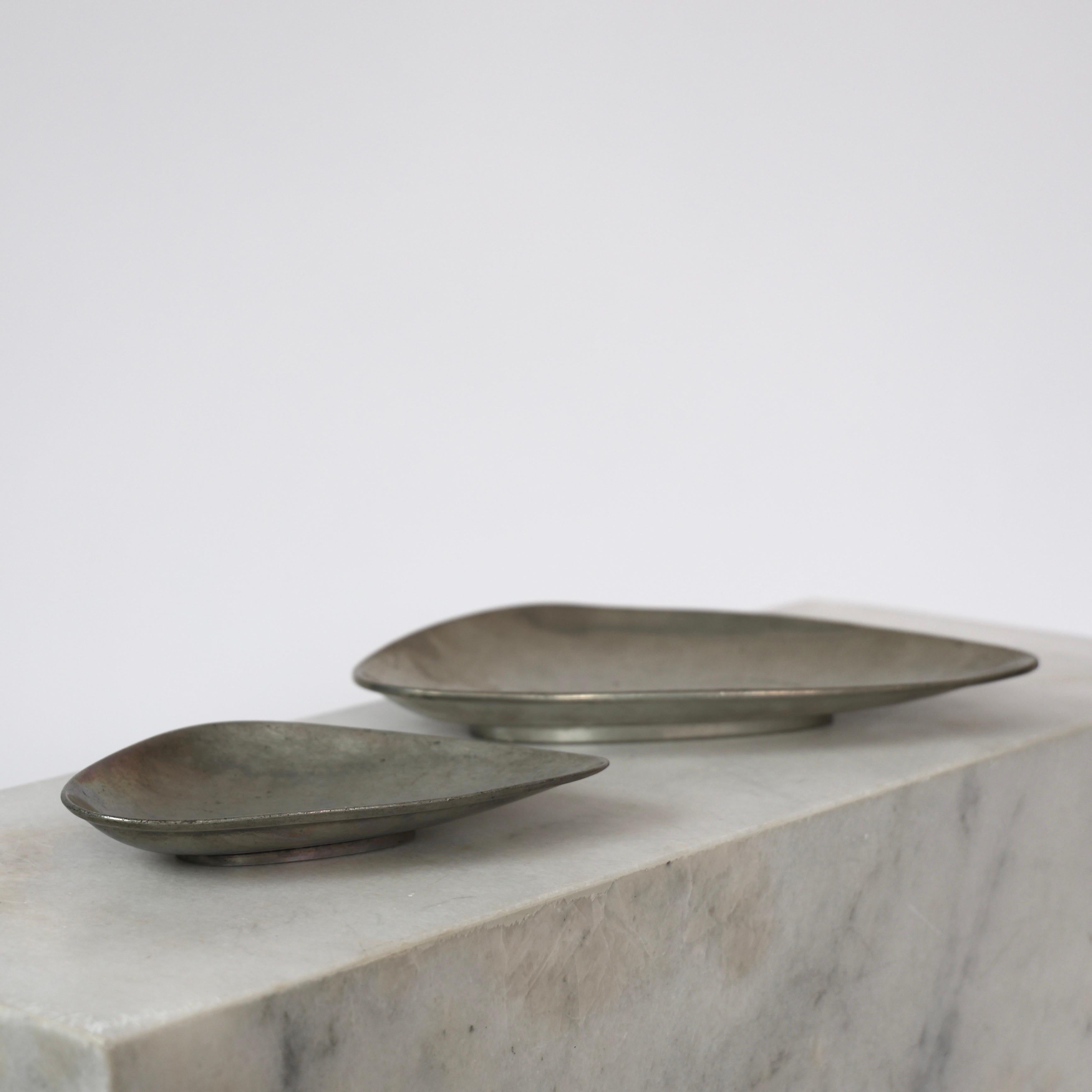 Elegant Pewter Plates designed by Arne Erkers for Just Andersen in the 1950s. 

* Set (2) of curvy pewter plates in two sizes 
* Designer: Arne Erkers
* Manufacturer: Just Andersen
* Style: 2618 & 2698
* Year: 1952
* Condition: Good vintage