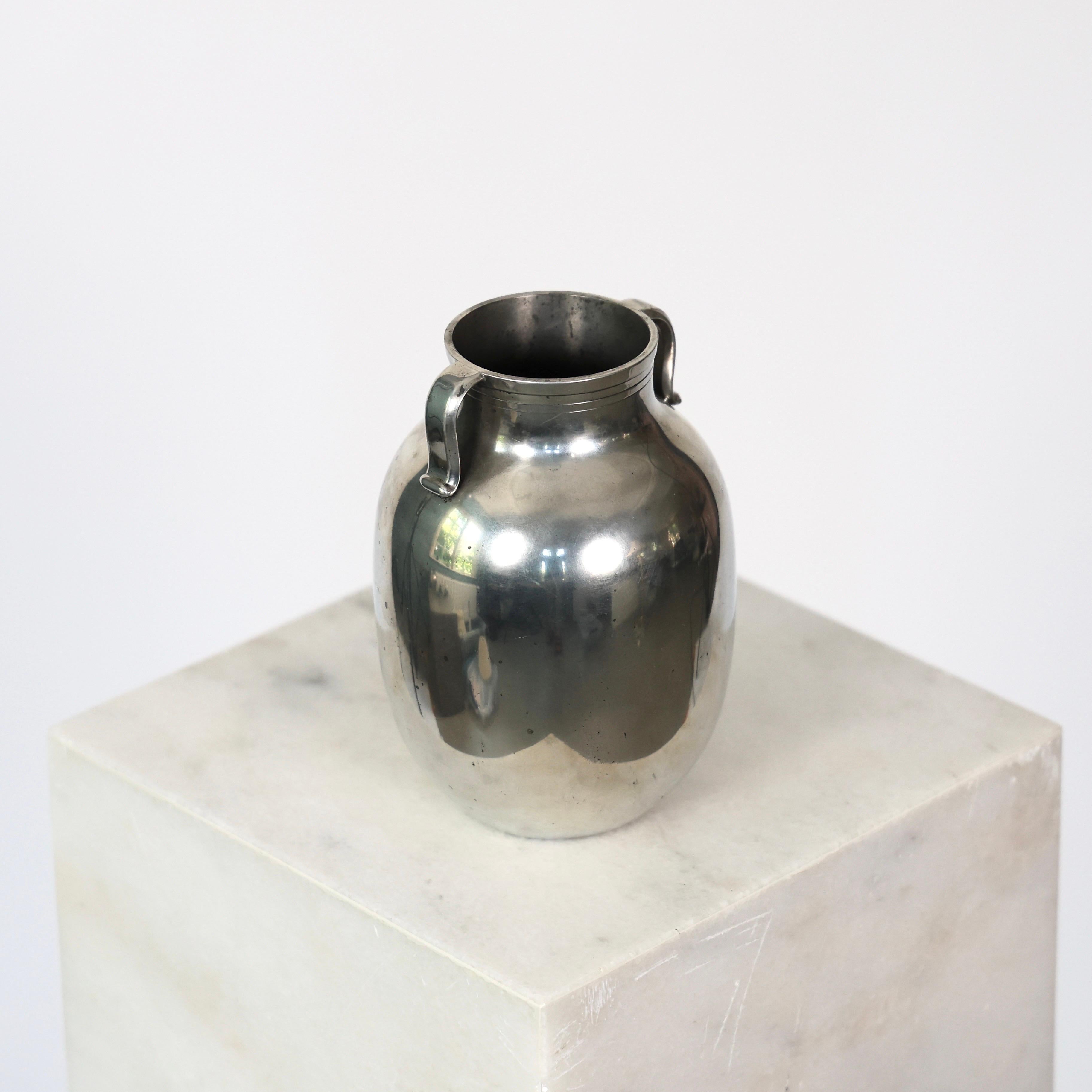 Elegante vaso in peltro in stile Amphora disegnato da Just Andersen negli anni Venti.

* Vaso in stile Amphora di peltro con anse 
* Designer: Just Andersen
* Model: 1801
* Anno: 1926-1929
* Condizioni: Buone condizioni vintage. Incisione del