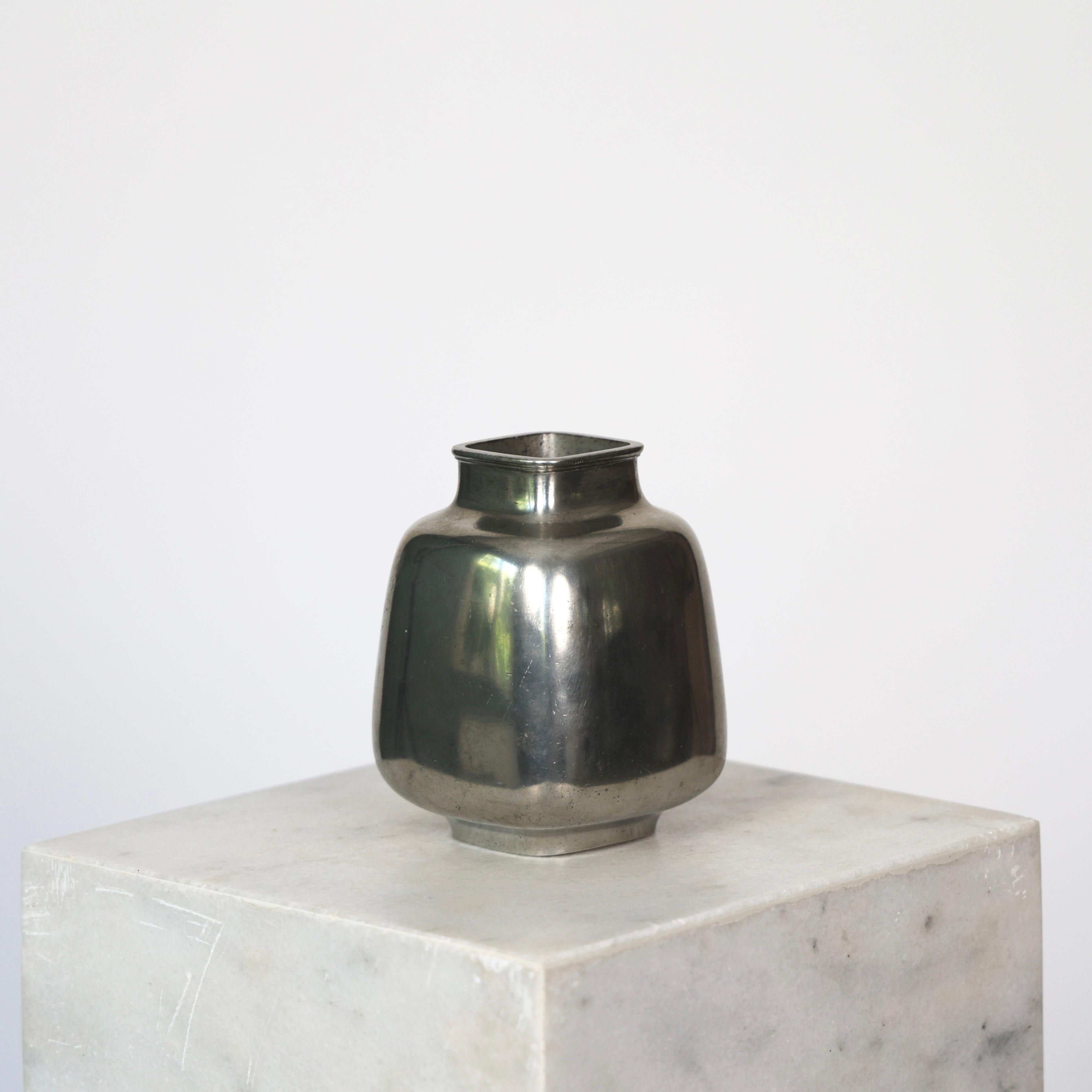 Substantial Square Pewter Vase made by Just Andersen in the 1950s. 

* Square pewter vase
* Manufacturer: Just Andersen
* Style: 2707
* Year: 1952
* Condition: Good condition. Makers engraving intact. Marks and surface scratches.  
* Dimensions (H x