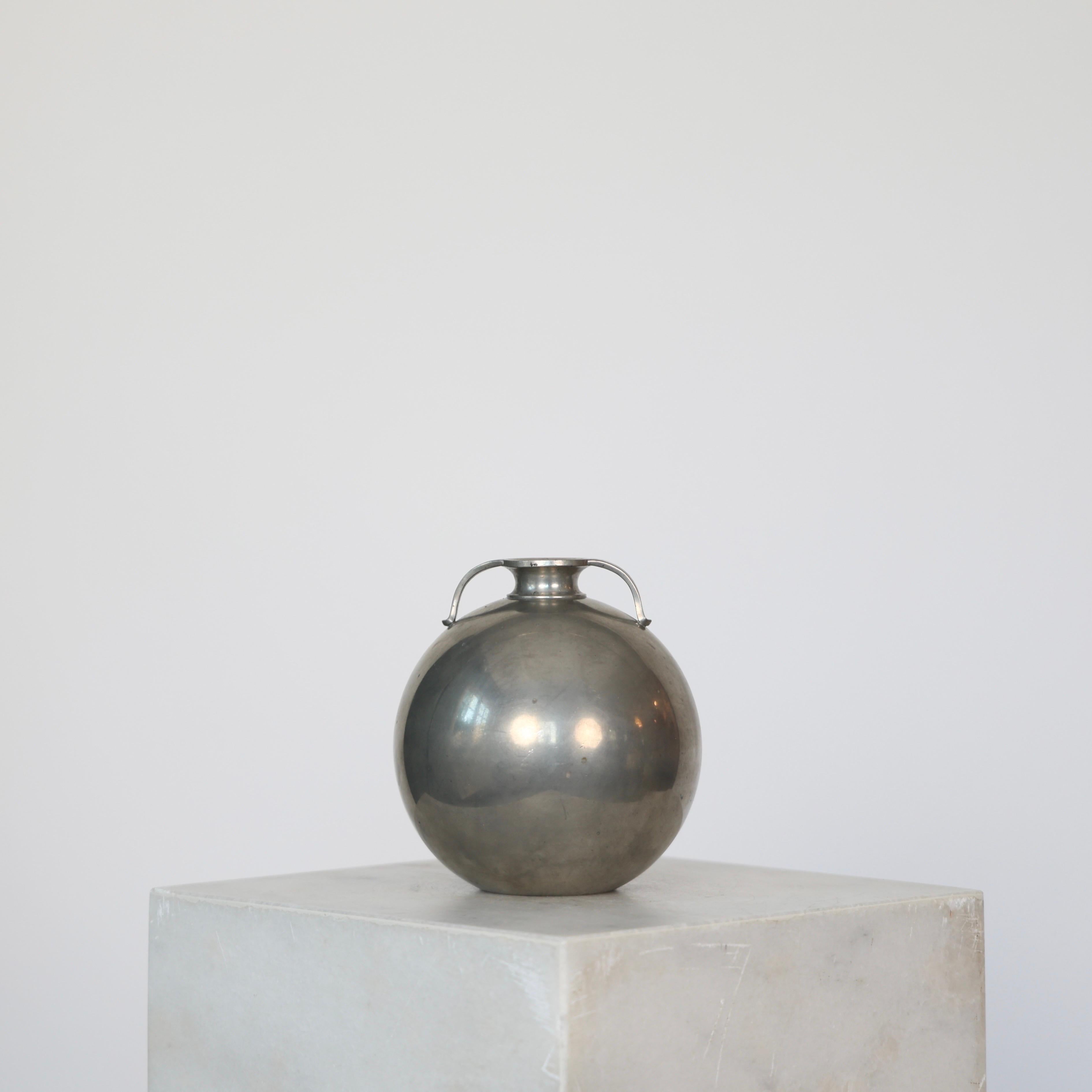 Elegante vaso rotondo in peltro realizzato da Just Andersen negli anni '30.

* Vaso rotondo in peltro con anse
* Designer: Just Andersen
* Stile: 1662 (timbro 'Just 1662')
* Anno: 1933
* Condit: Discrete condizioni vintage. Incisione del costruttore